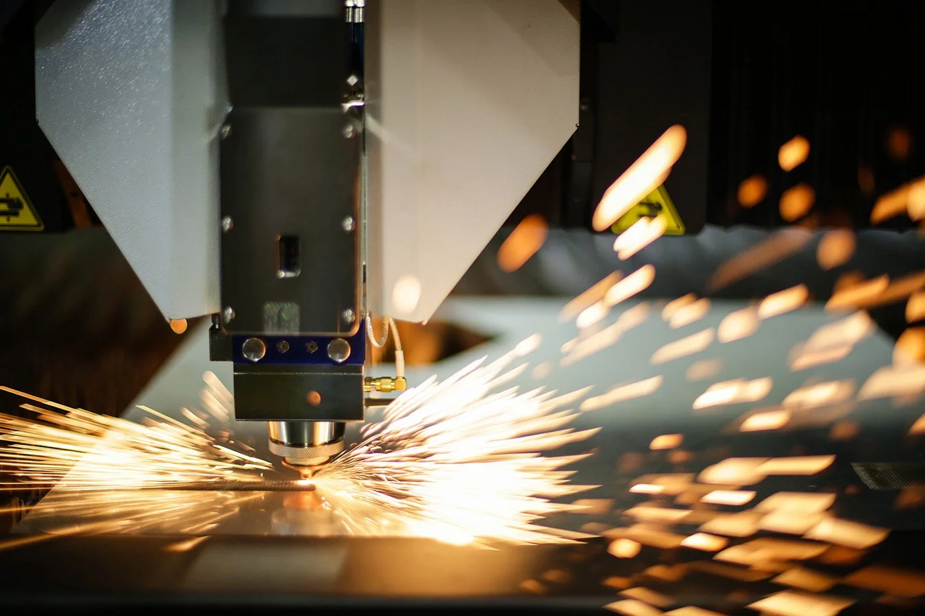 A robotic welding machine sparks as it welds a metal piece in an industrial setting.