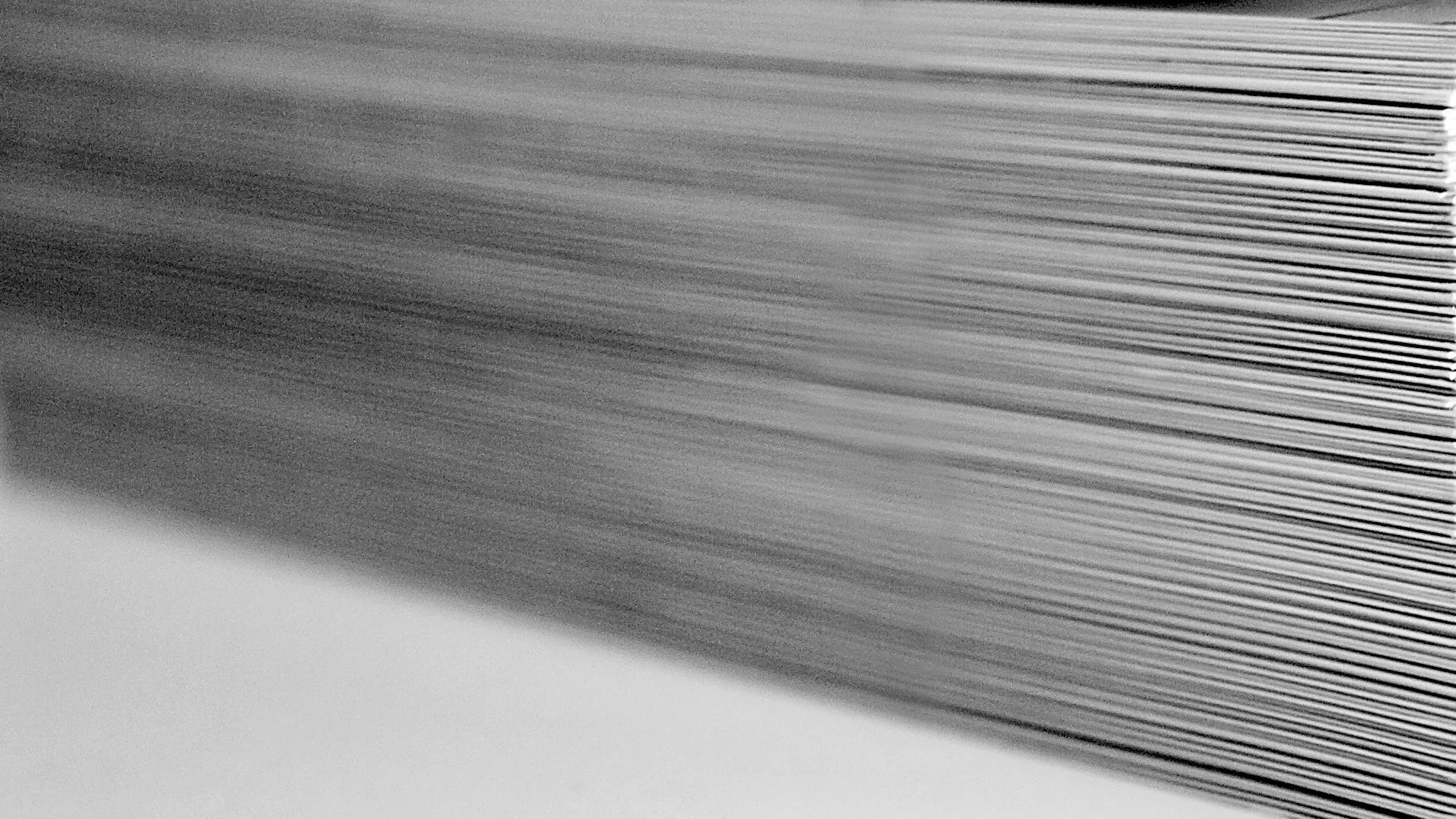 Close-up of stacked sheets of paper forming diagonal lines and texture.