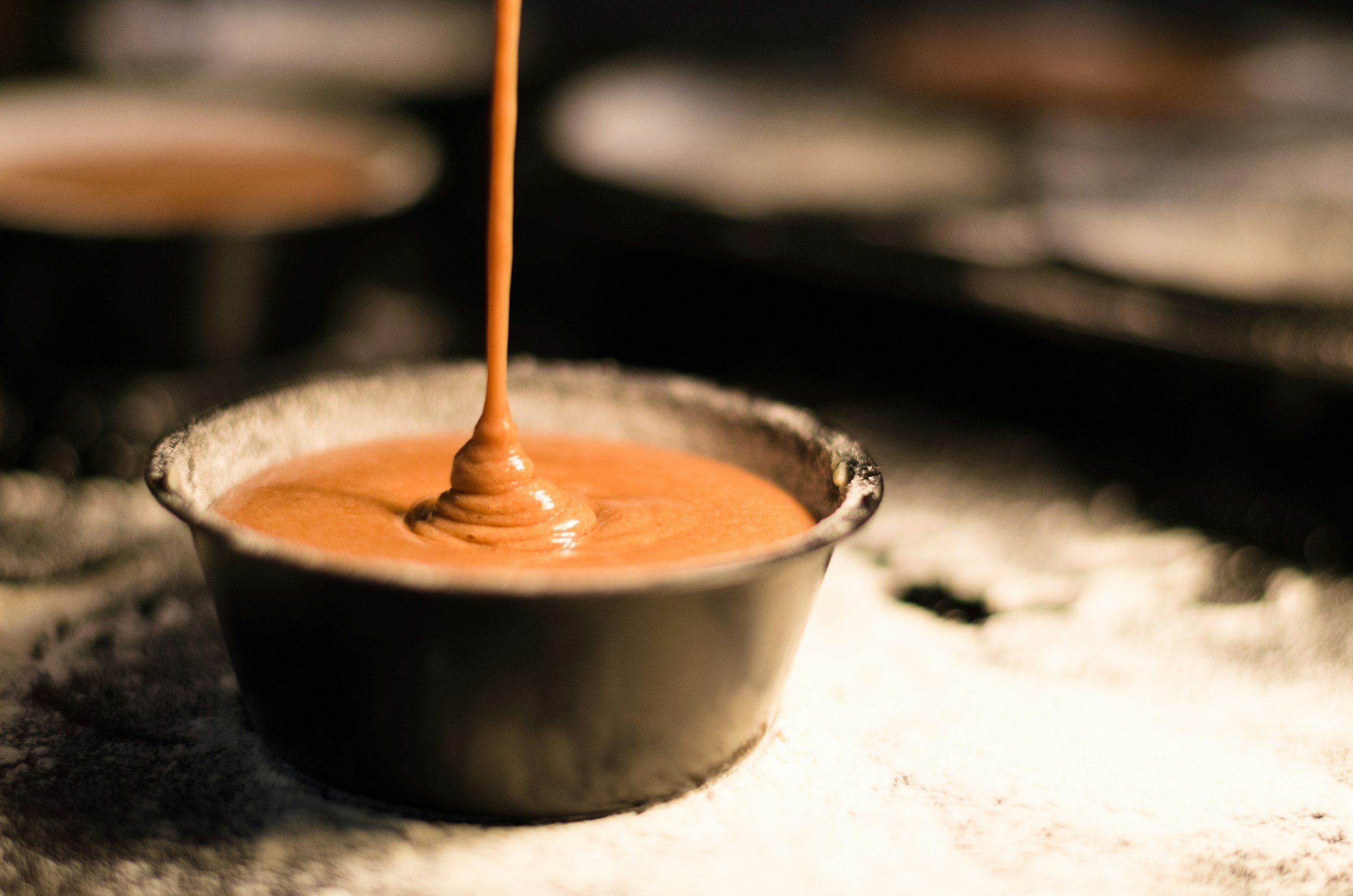 Chocolate batter being poured into a baking mold.