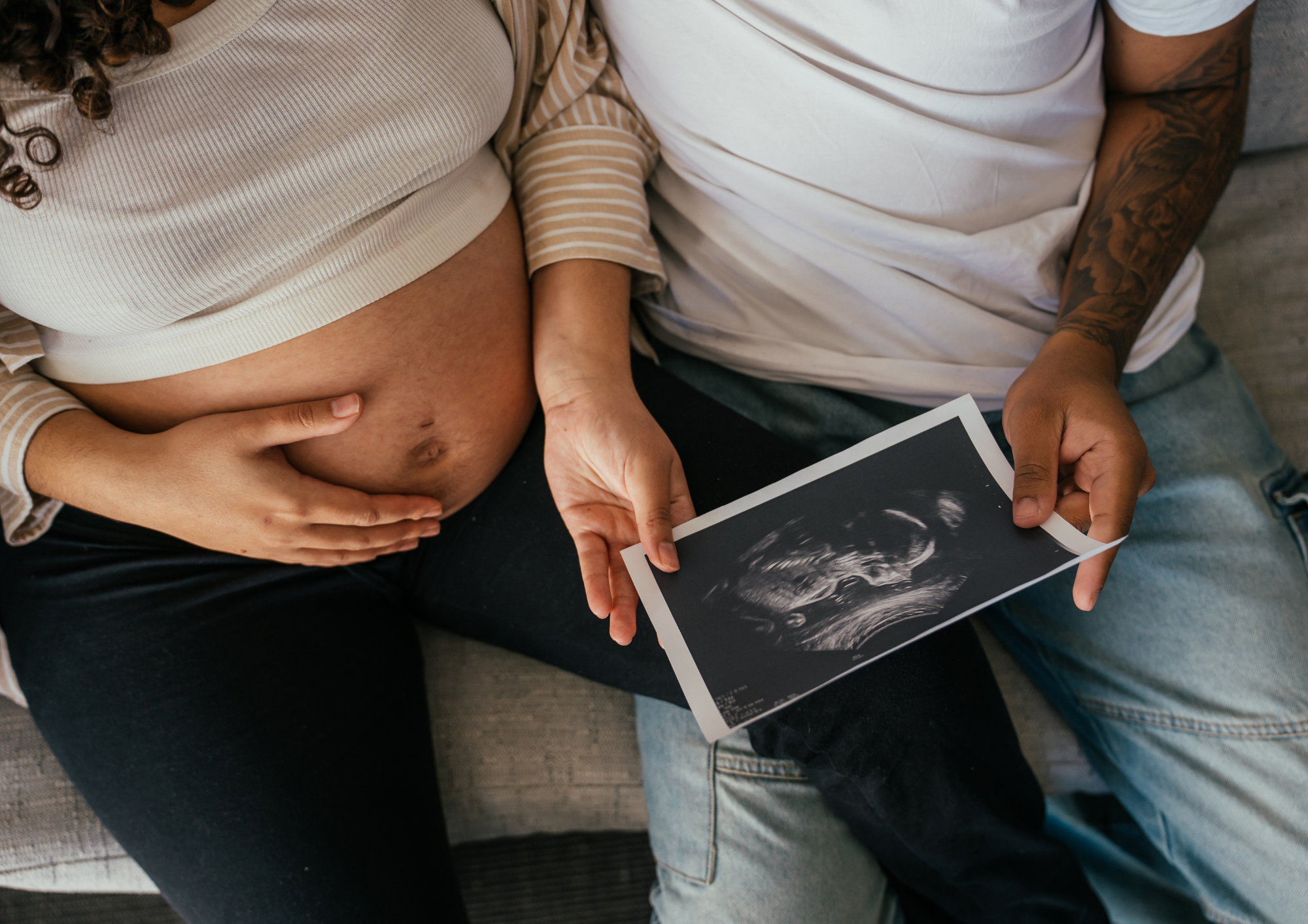 Expecting parents holding an ultrasound image together