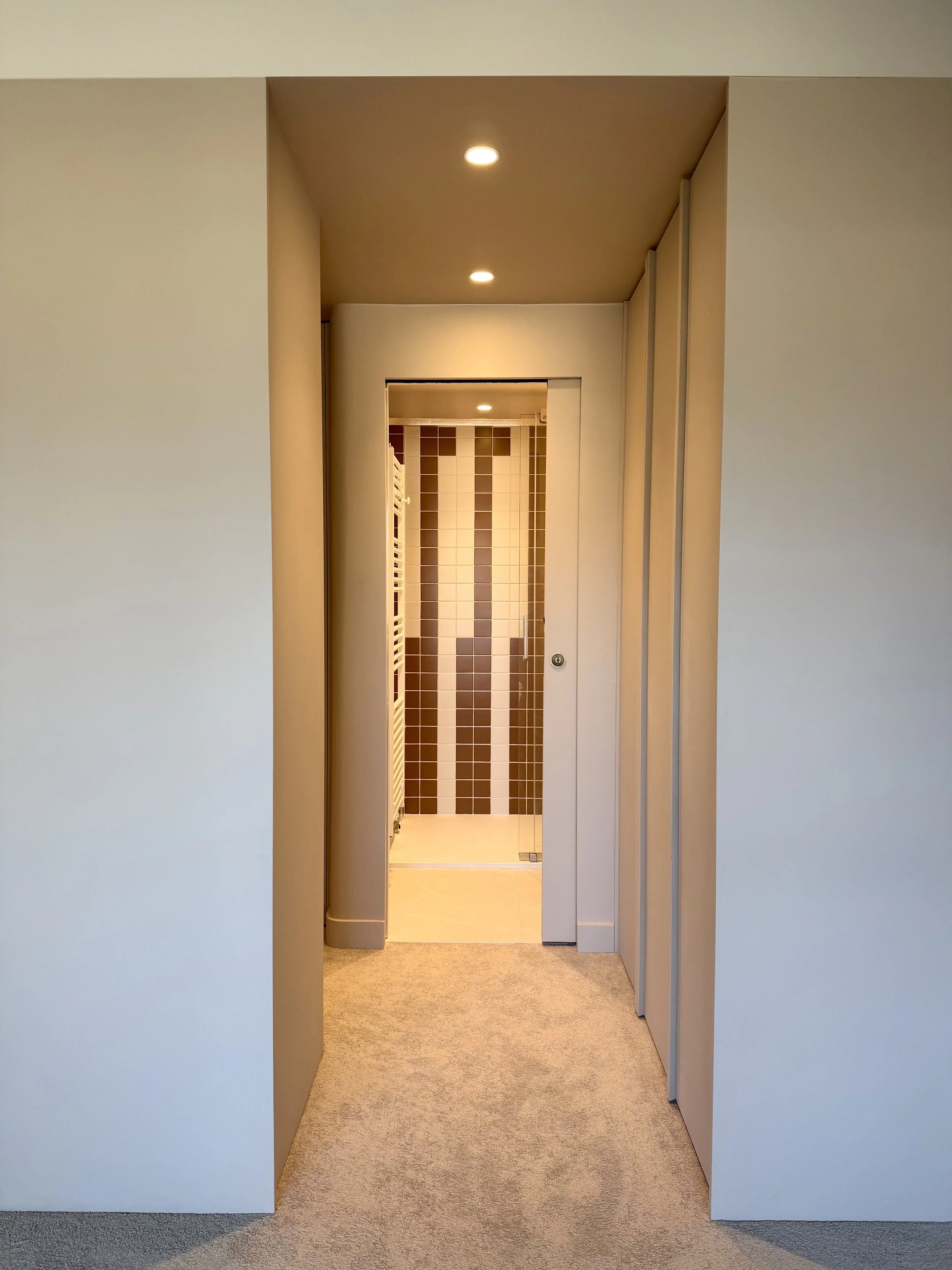 Espace chambre avec dressing et accès à la salle de bain.