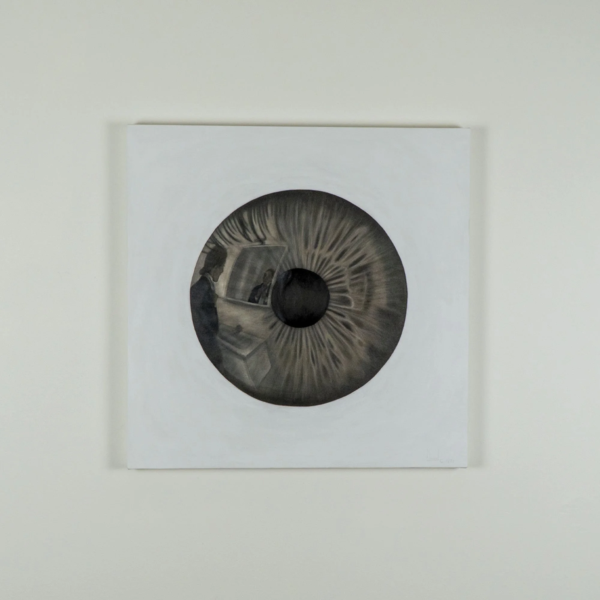 Il dipinto dell'artista Manuel Capaccioli "Il mio bravo ragazzo" appeso alla parete, raffigurante un occhio marrone su sfondo bianco.