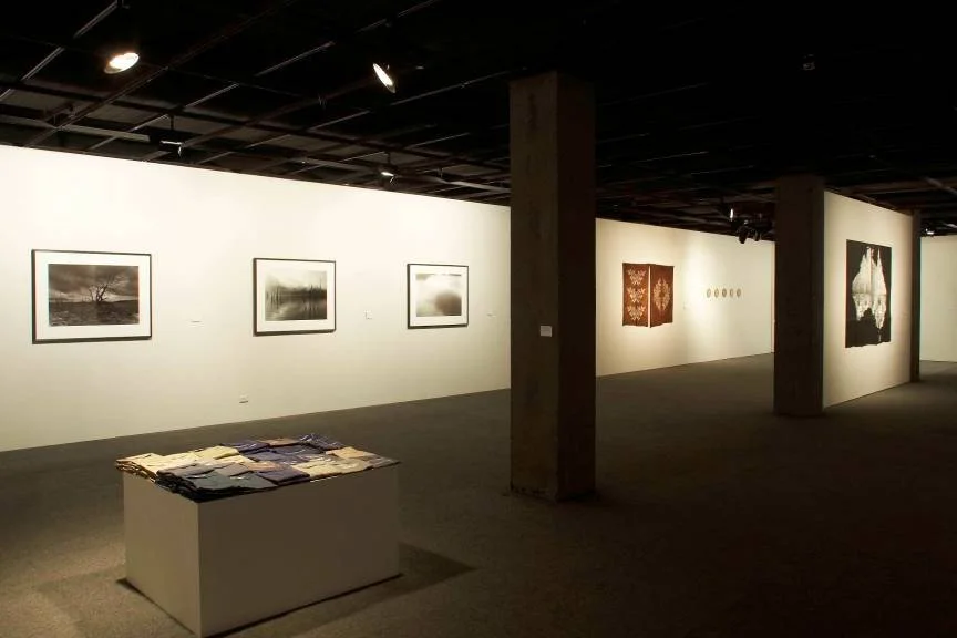 Front left: Susanna Castleden, 'Abandoned (Near Wittenoom)' 2004, embroidered work shirts on plinth. Rear left: David Stephenson, 'Drowned' series, 2001, toned silver gelatin prints. Rear right: Holly Story, 'Salt I and II', 2002, blankets, plant dye