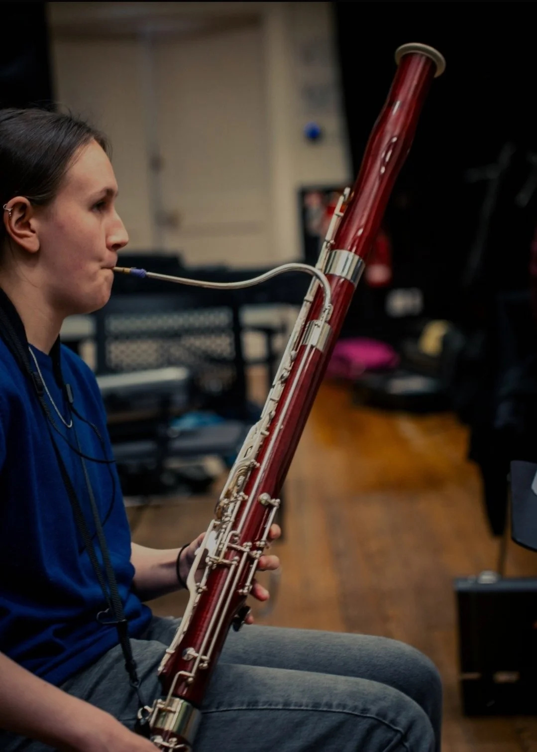 A person playing a bassoon in a music studio.