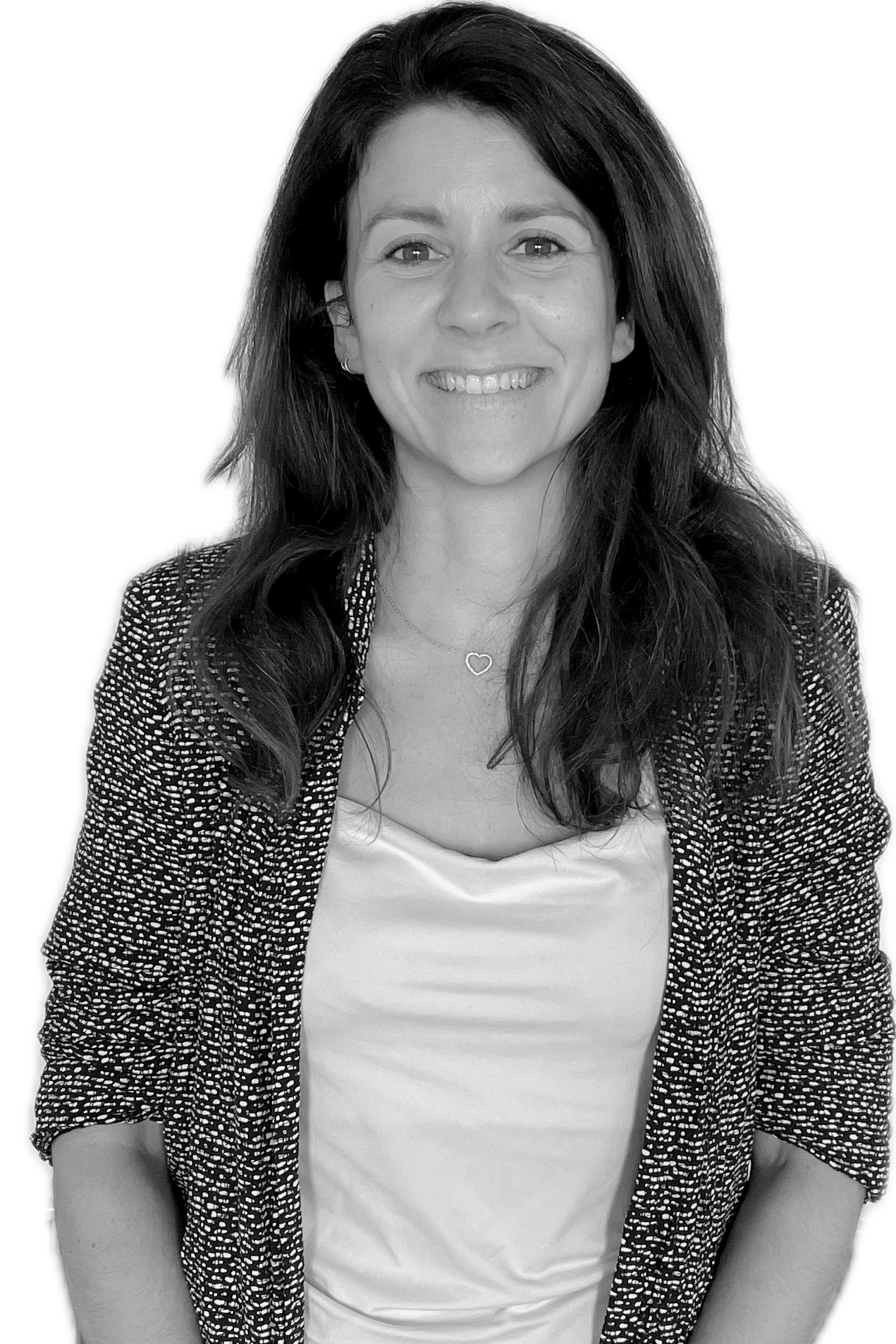 Black and white portrait of a woman with long dark hair, smiling, wearing a patterned blazer over a light-colored top, and a delicate heart-shaped necklace.