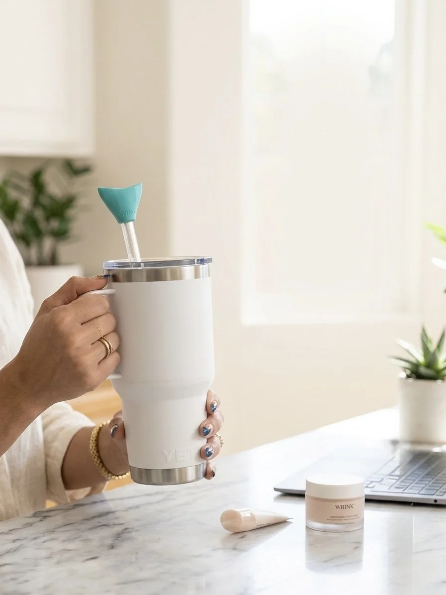wrinx straw attachment on white tumbler being held by a womans hand with gold rings
