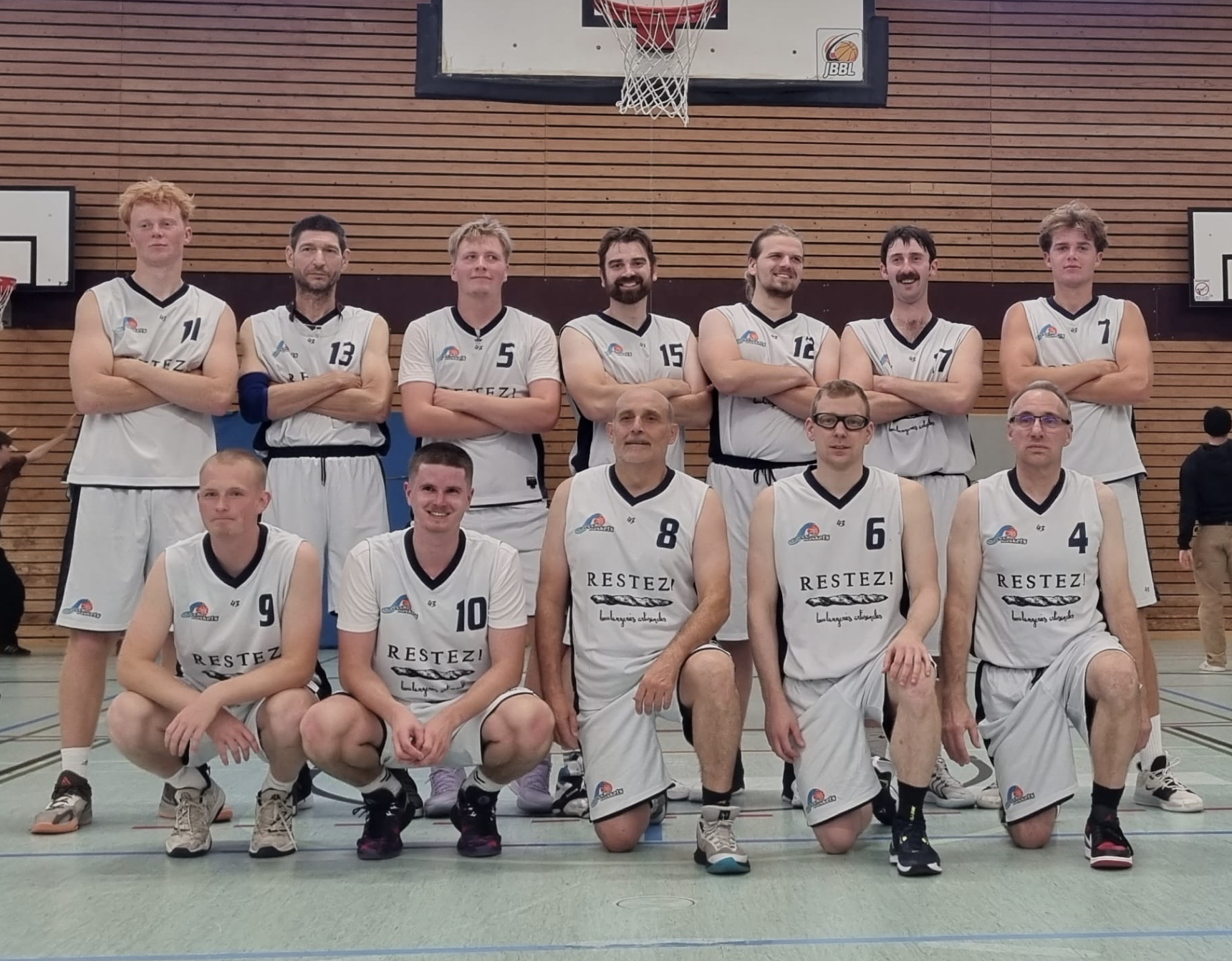 Ein Basketballteam fotografiert in einer Turnhalle.