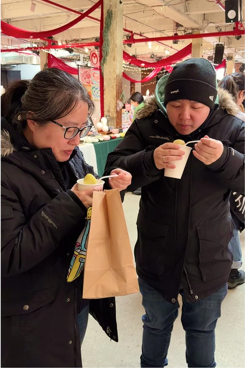 Two customers at Ouri Market in Greenpoint, Brooklyn enjoying Chenzi’s Fuzhounese potato balls.