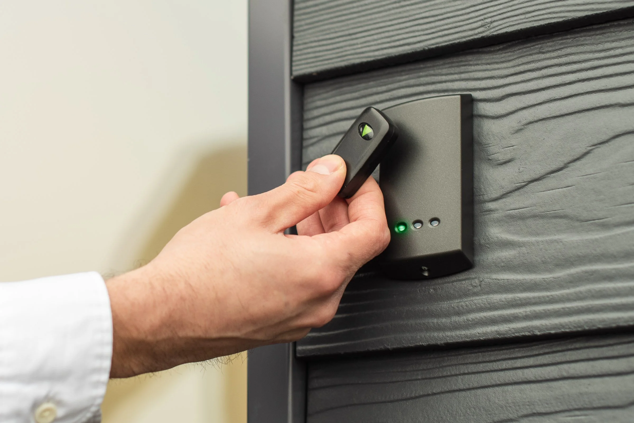 Access control key fob being presented to a wall-mounted door entry reader