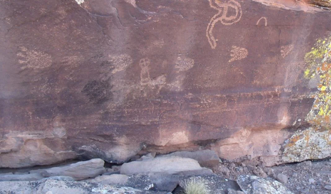 Glyphs of bear paw prints on the boulder.