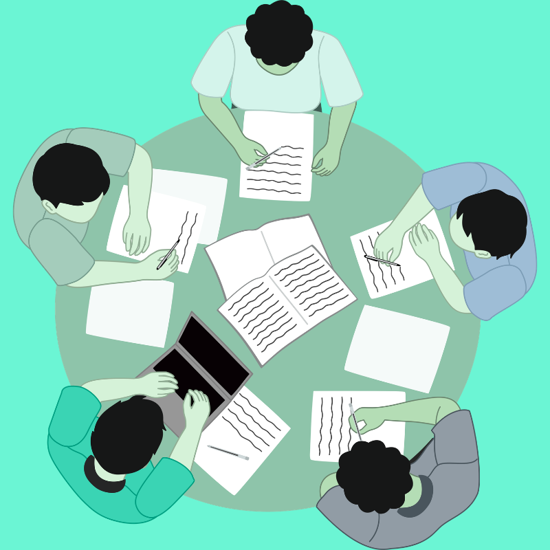 Top-down view of six people sitting around a round table, working on documents with papers, notebooks, and a laptop.