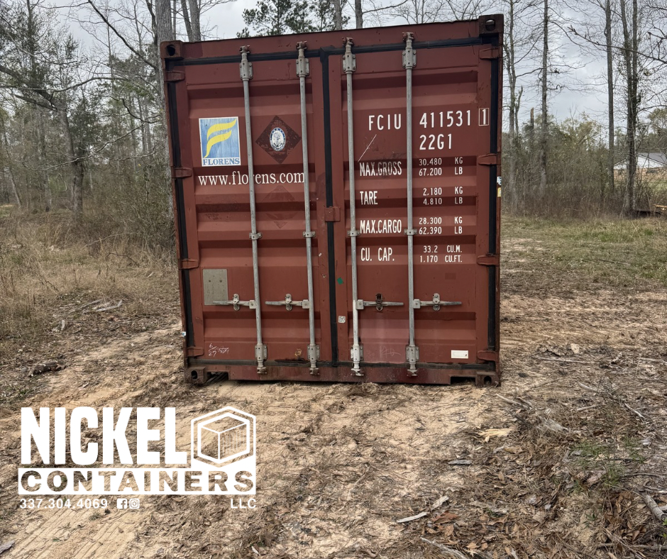 A red shipping container outdoors on dirt ground, surrounded by trees and a cloudy sky. The container has two vertical bars on the doors and various labels and markings, including a large logo for FloRenS, website URL, and weight specifications.