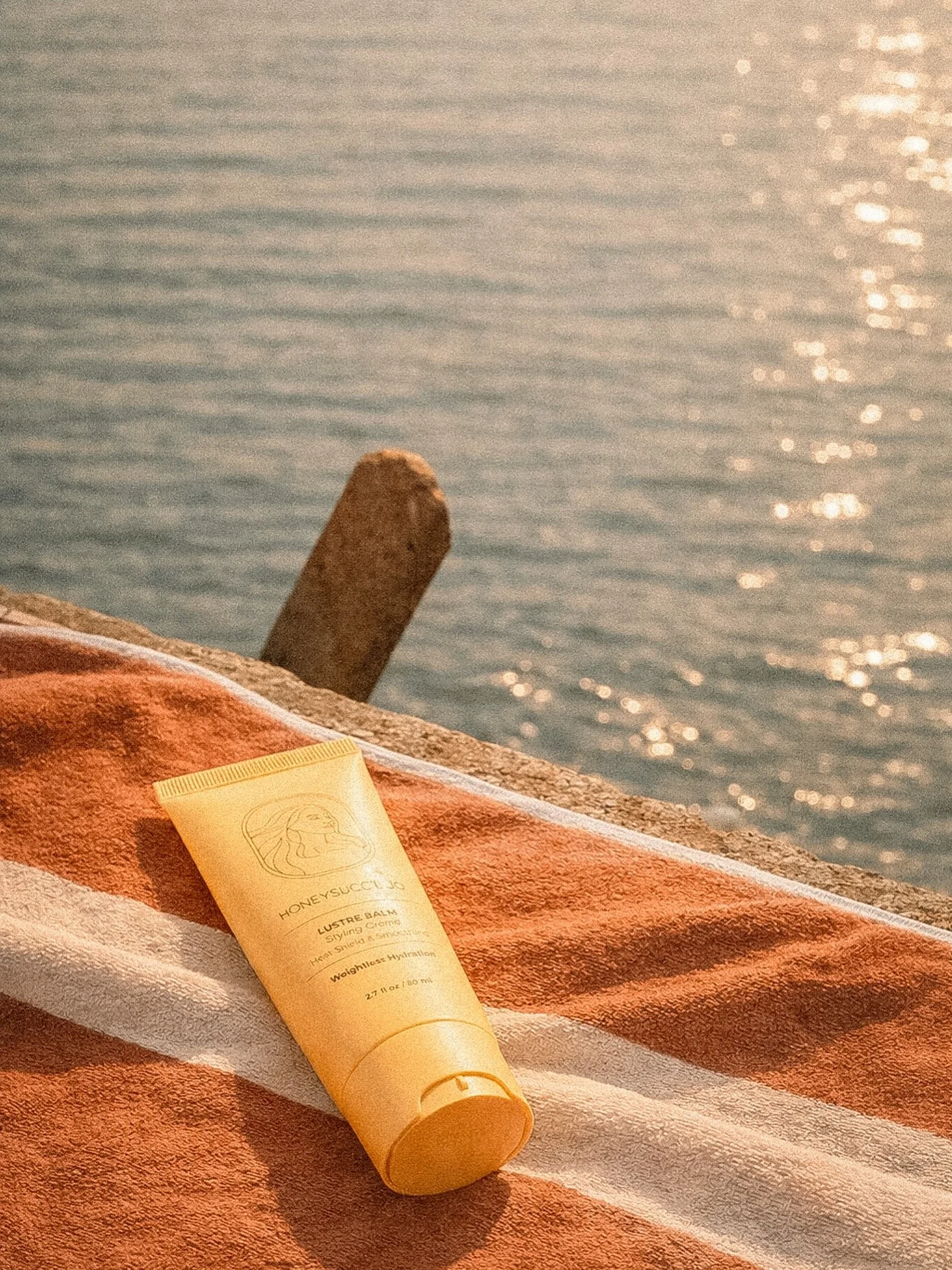 Salt air, soft strands. 
LUSTRE BALM tames frizz, adds natural shine, and keeps every wave as smooth as the tide&mdash;without weighing hair down.

Enriched with coconut, argan, sunflower seed oil, honey, and sodium hyaluronate for hydrated, touchabl