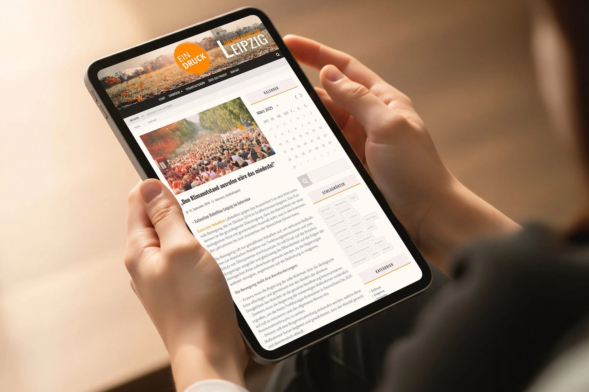 Close-up of a person holding a smartphone that displays a website with an image of a large crowd at a protest or rally, and text in German about climate change.