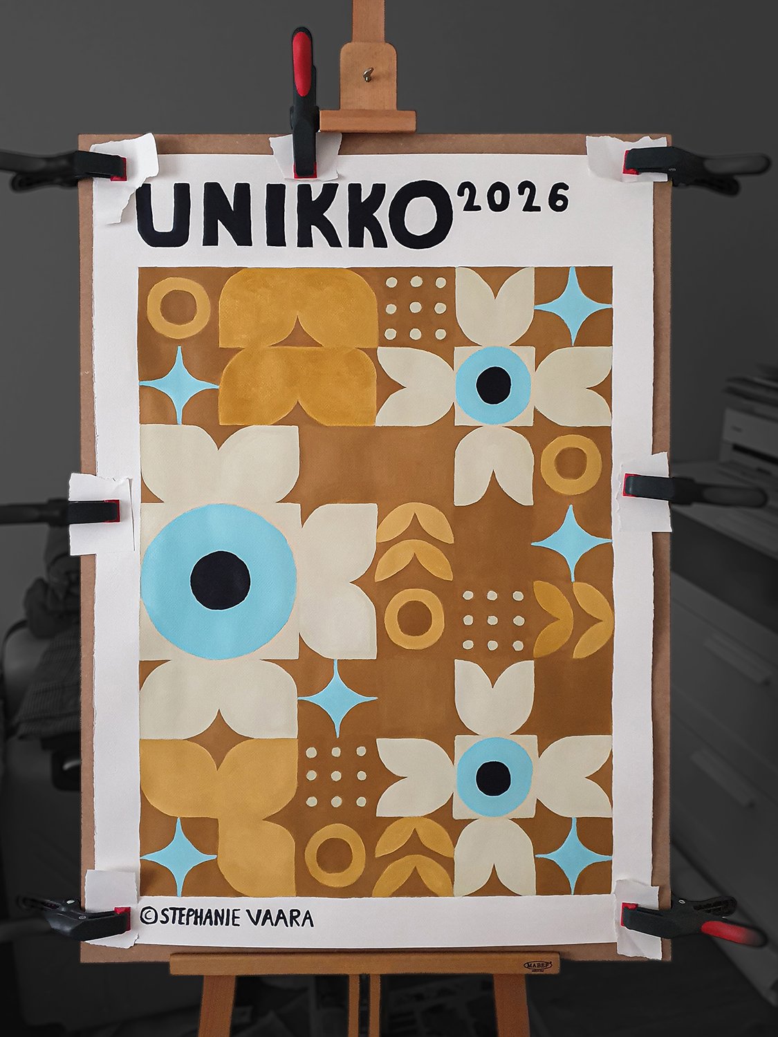 Abstract geometric artwork with floral and star patterns in beige, blue, yellow, and white, signed by Stephanie Vaara, titled "UNIKKO 2026".