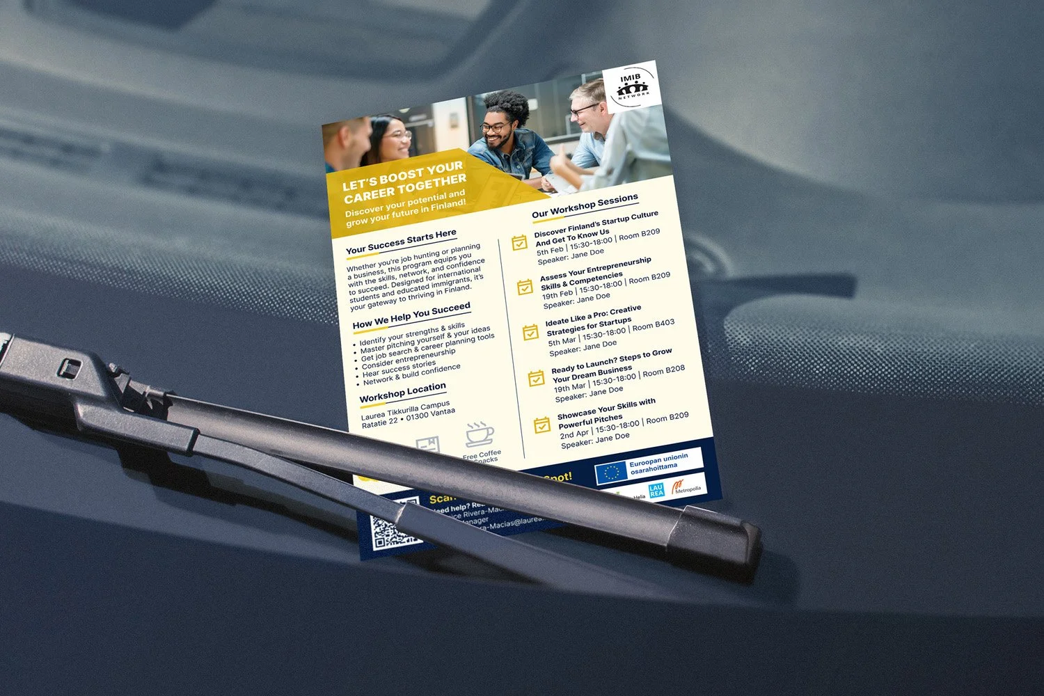 A flyer placed on a car dashboard advertising a workshop series to boost career potential in Finland. The flyer features a photo of a diverse group of people smiling and working together at the top. It includes sections about workshop sessions, with 