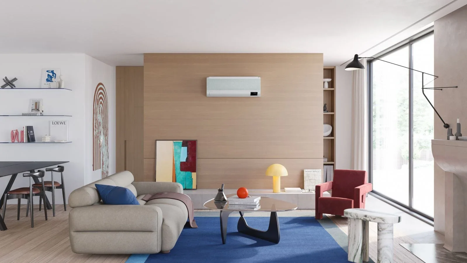 Modern living room with beige sofa, red armchair, blue rug, coffee table, artwork, and sliding glass doors.