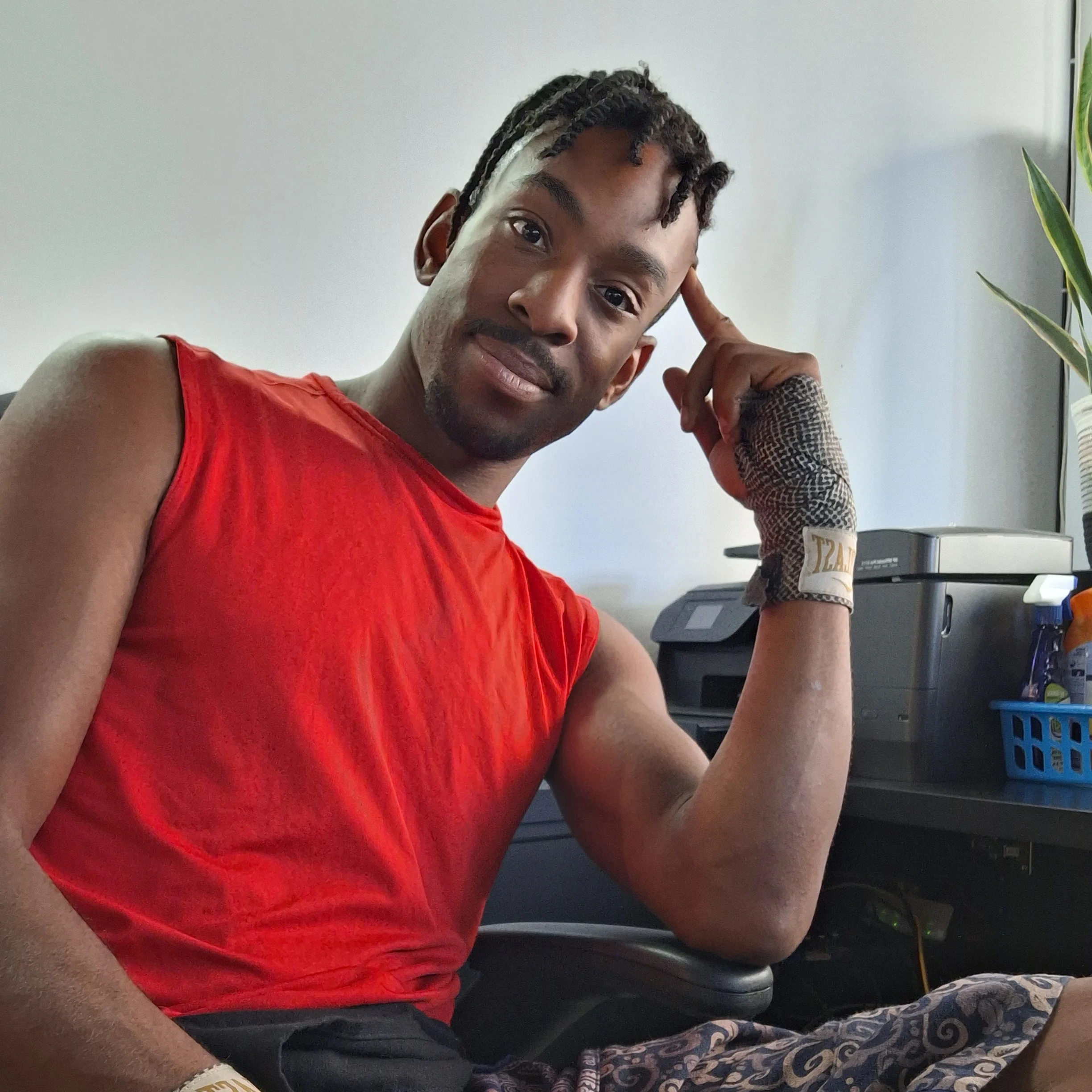 Image of Coach AD smiling with hand wraps and a bright red muscle tee