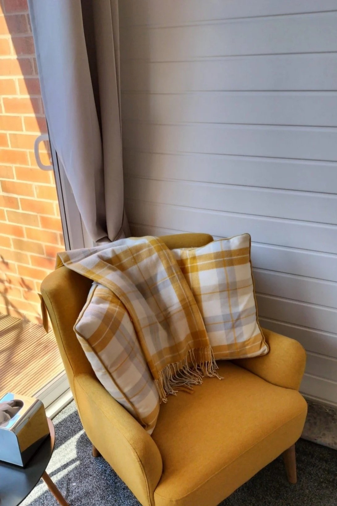A comfortable counselling chair in a bright therapy room with natural light, ready for one-to-one therapy sessions for teachers.