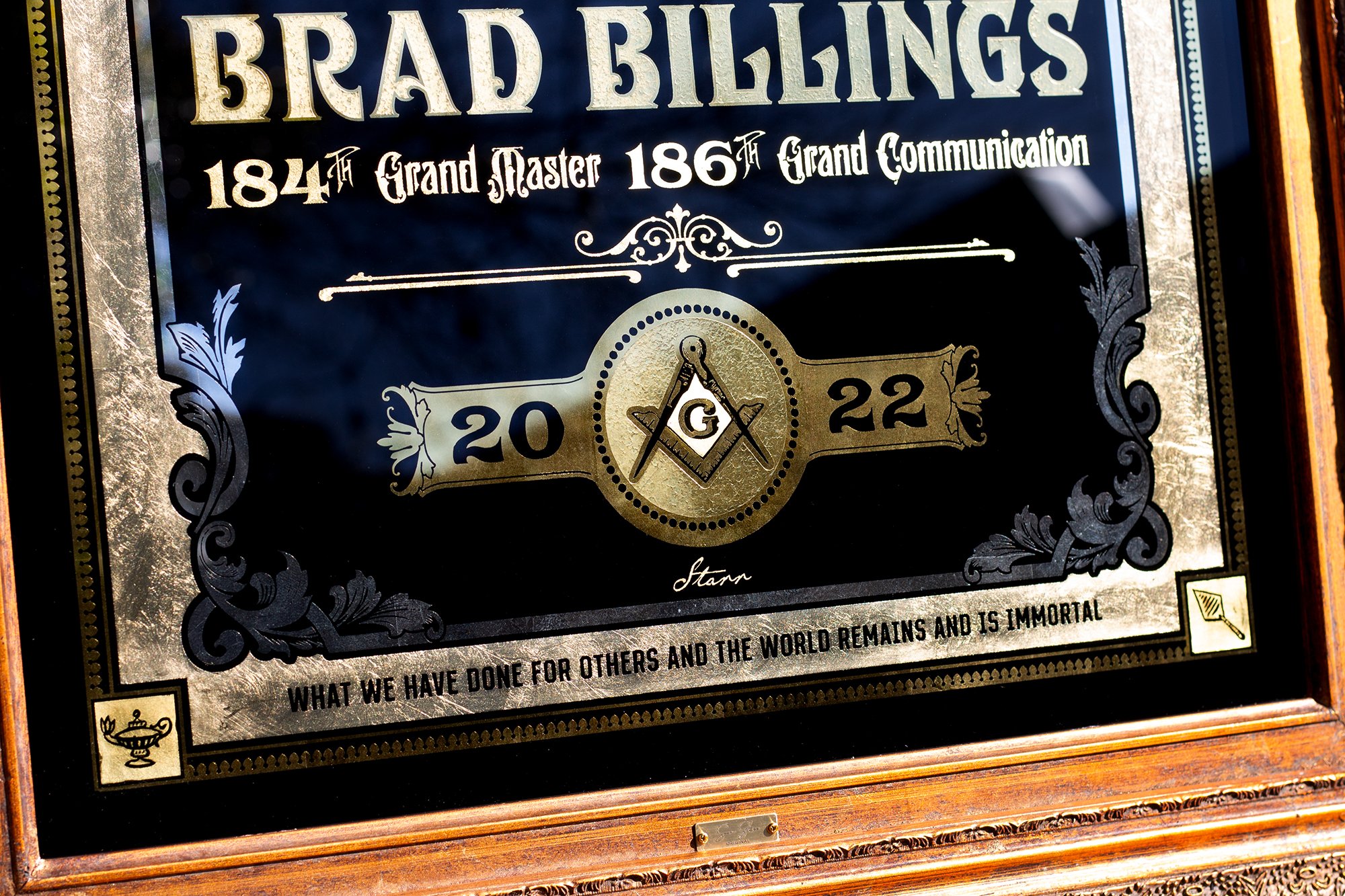 A decorative plaque commemorating Bread Billings, with the years 1841 and 1861, Masonic symbols, and an inscription about doing good for others.