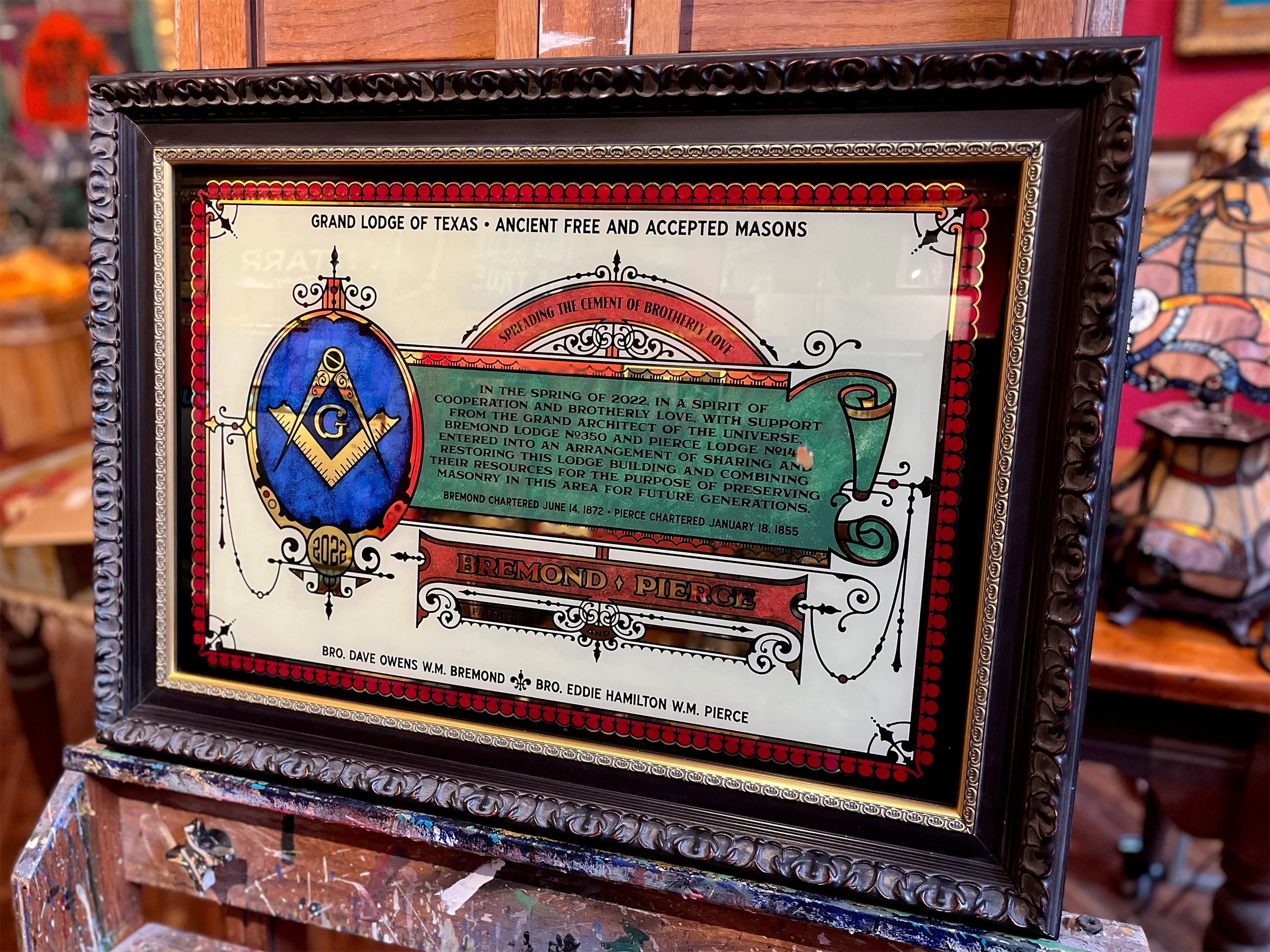 Framed certificate featuring Masonic symbols and text related to the Grand Lodge of Texas, with ornate frame and decorative design.