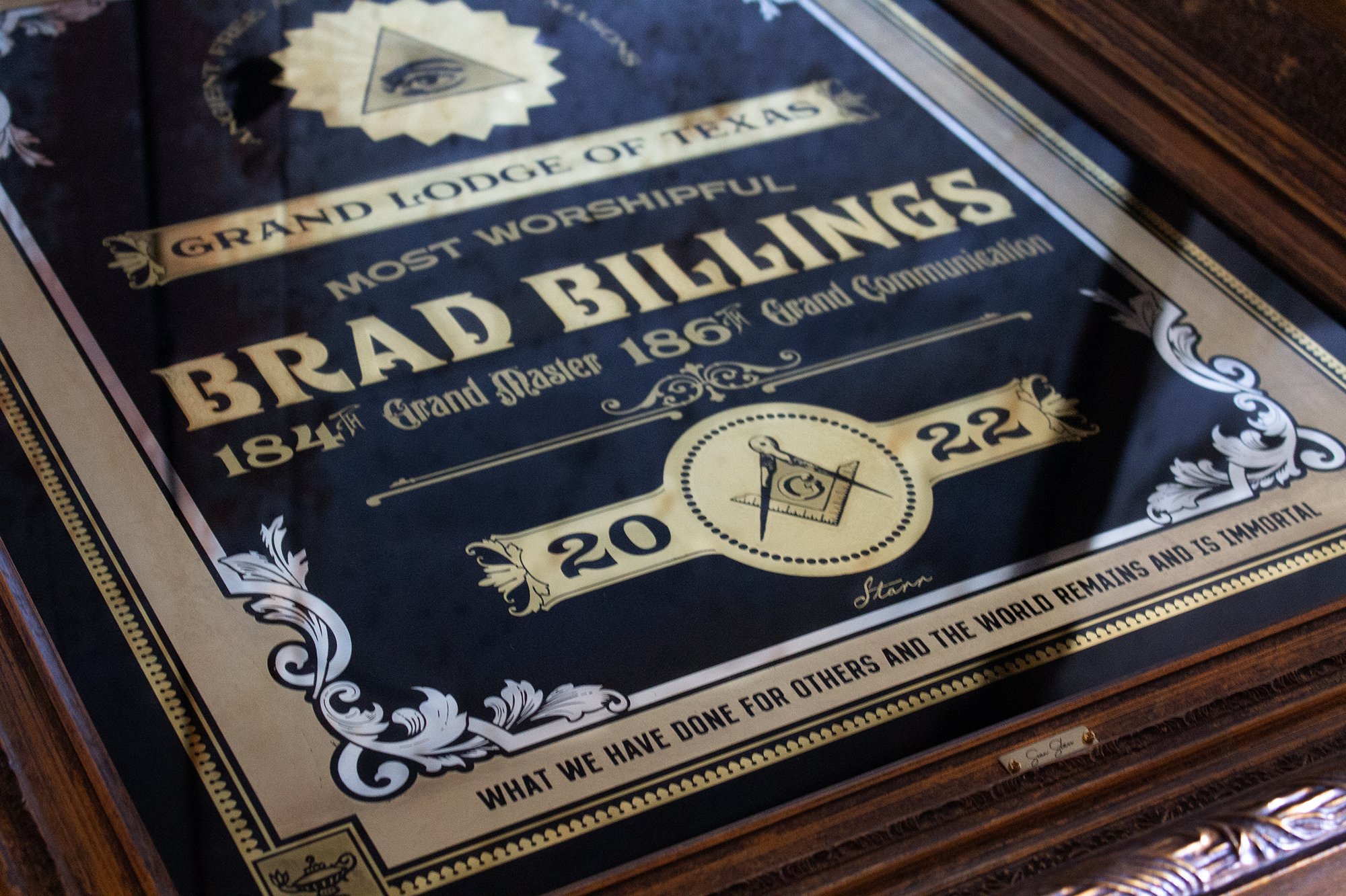 Decorative plaque with ornate border, containing text about Bradford Masonic Lodge of Texas from 1862, with the years 1844 and 22, and a logo of a compass and square, mentioning what has been done for others and the world.