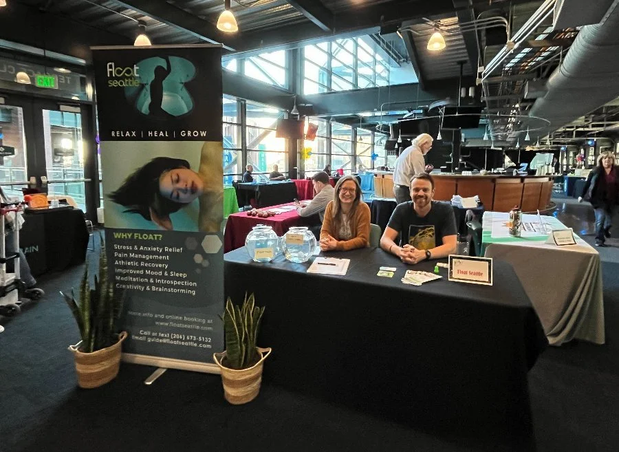 Two Float Seattle team members at a community event table