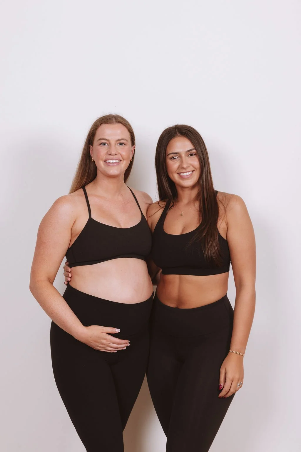 Rilee Okere and Emmy, instructors at REform Pilates Studio in Columbia, Missouri, standing together in black activewear.