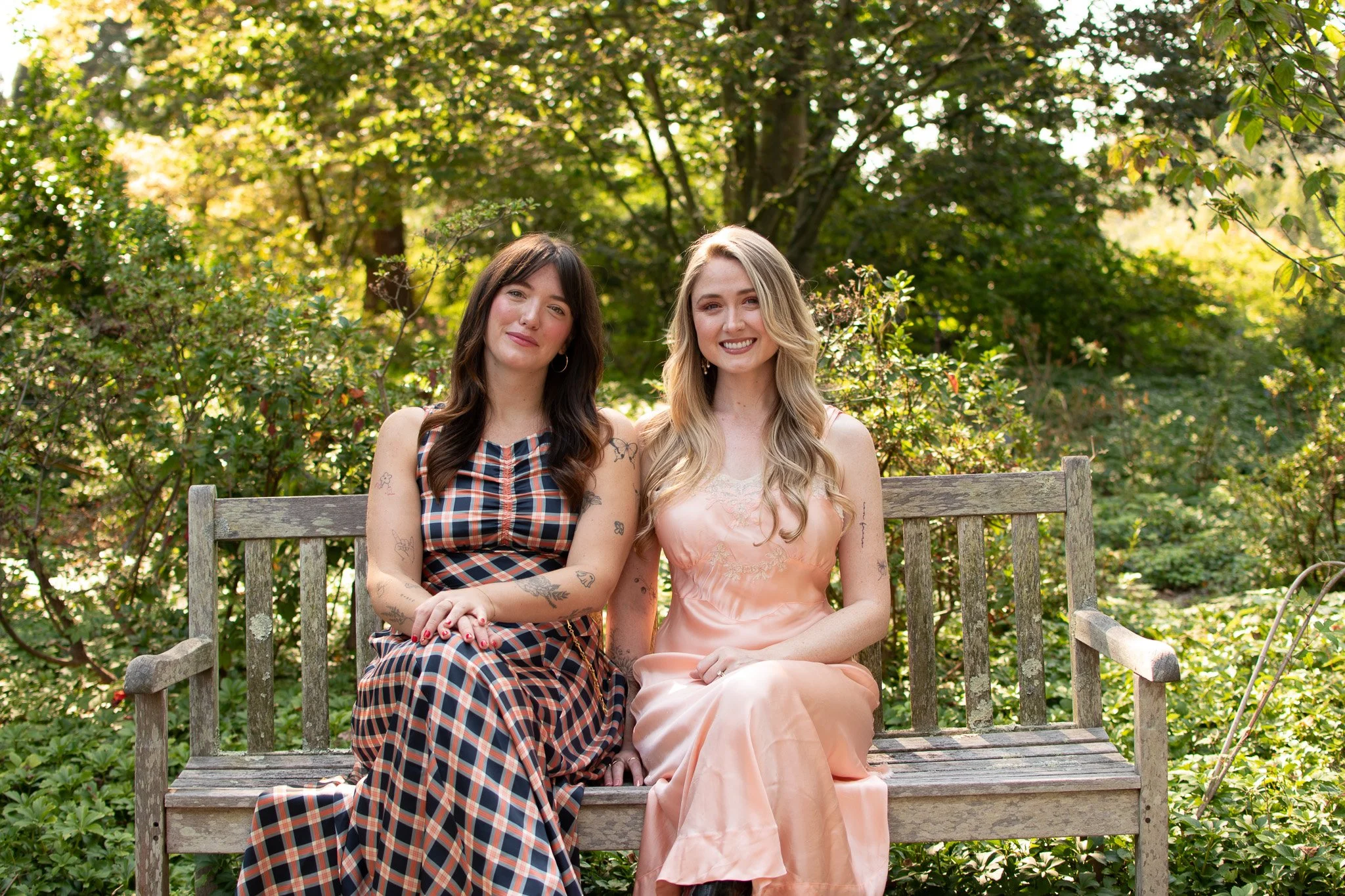 Two licensed therapist sitting on a bench with warm and compassionate smiles