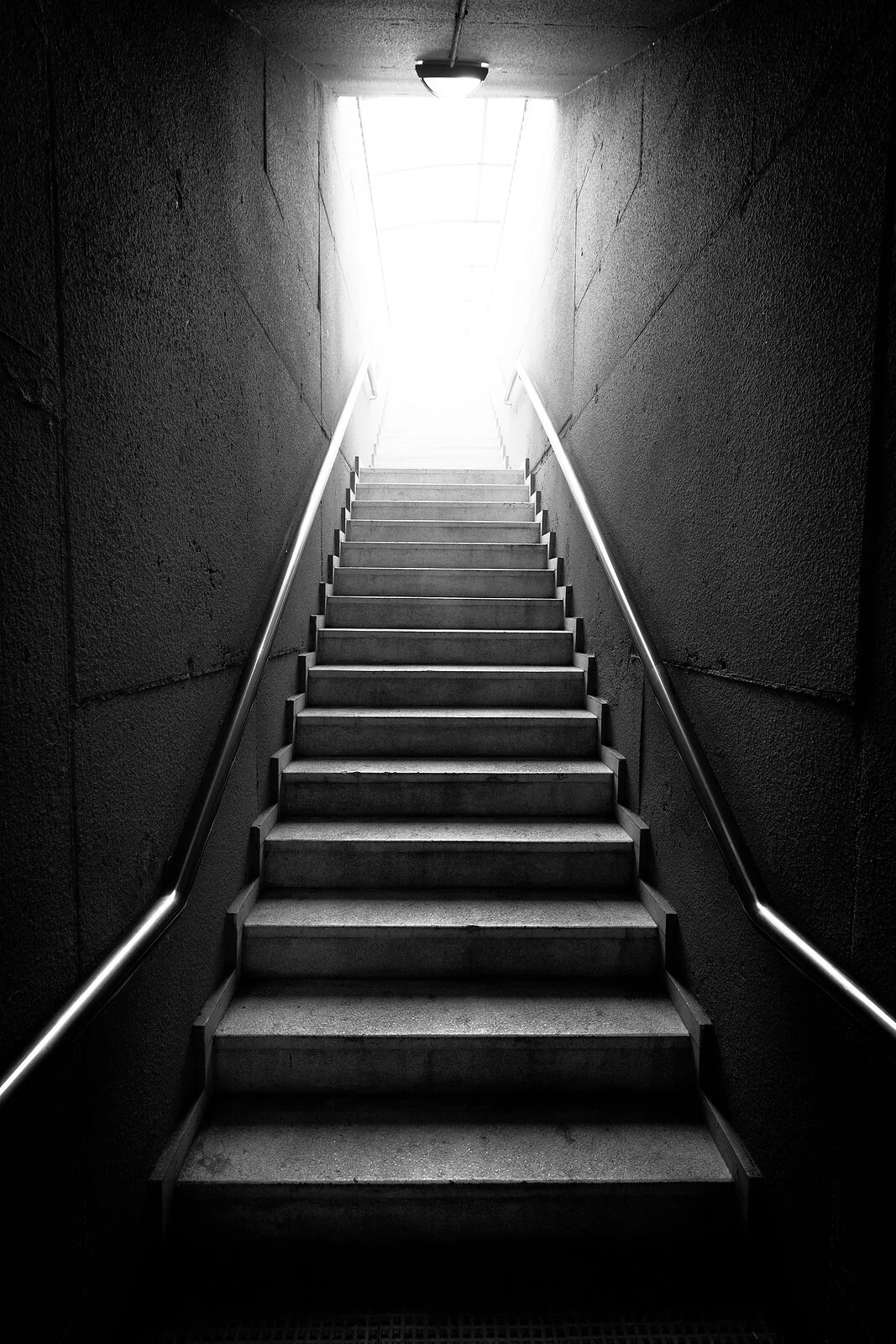 A dramatic black and white staircase rises from darkness. Is disgust-based contamination OCD keeping you trapped in darkness, unable to move toward the life you want? An OCD therapist in Wauwatosa, WI, can help you find your way forward.