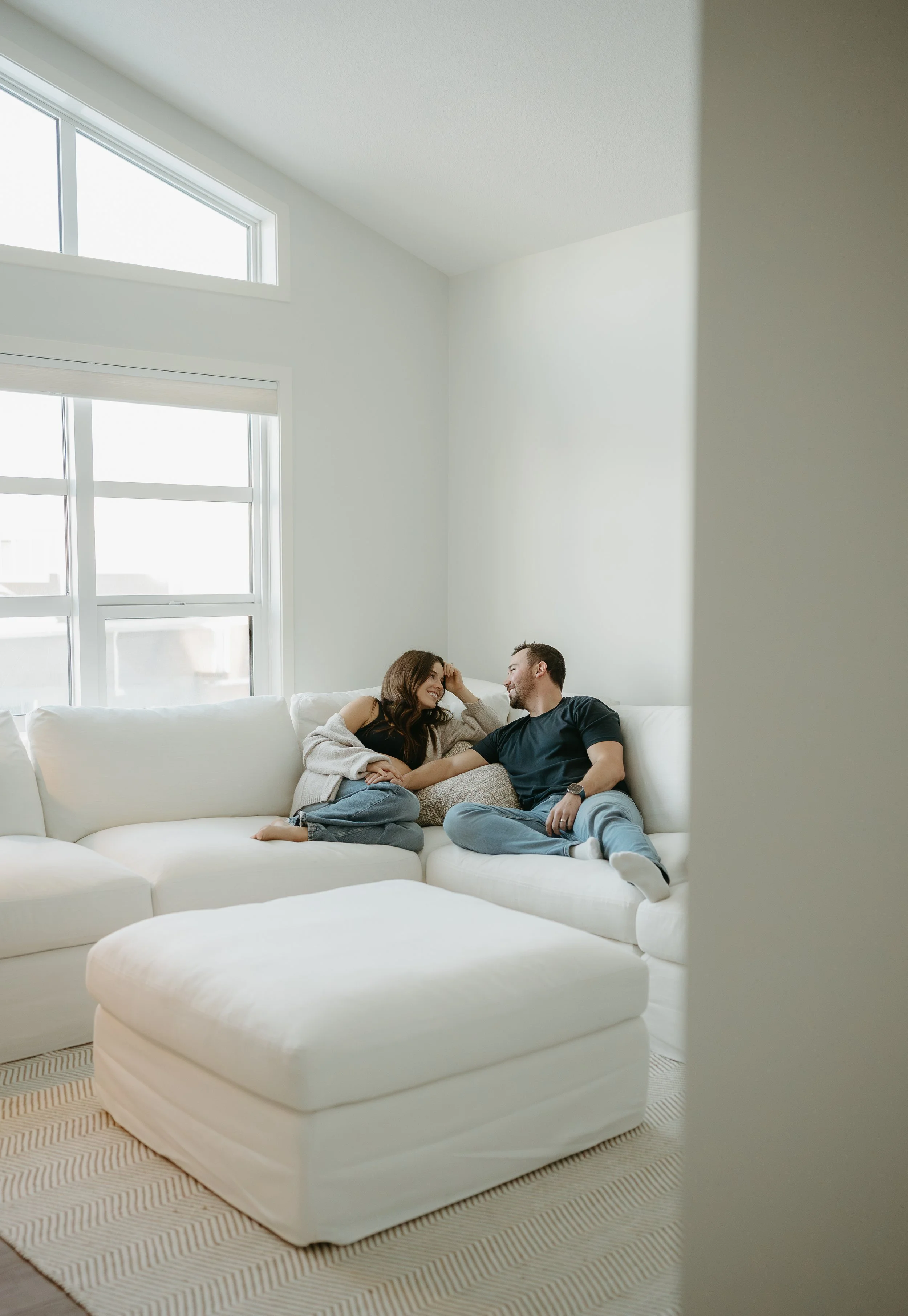 Calgary Alberta Maternity and Newborn Photographer. Couple sitting on couch in living room for a maternity session