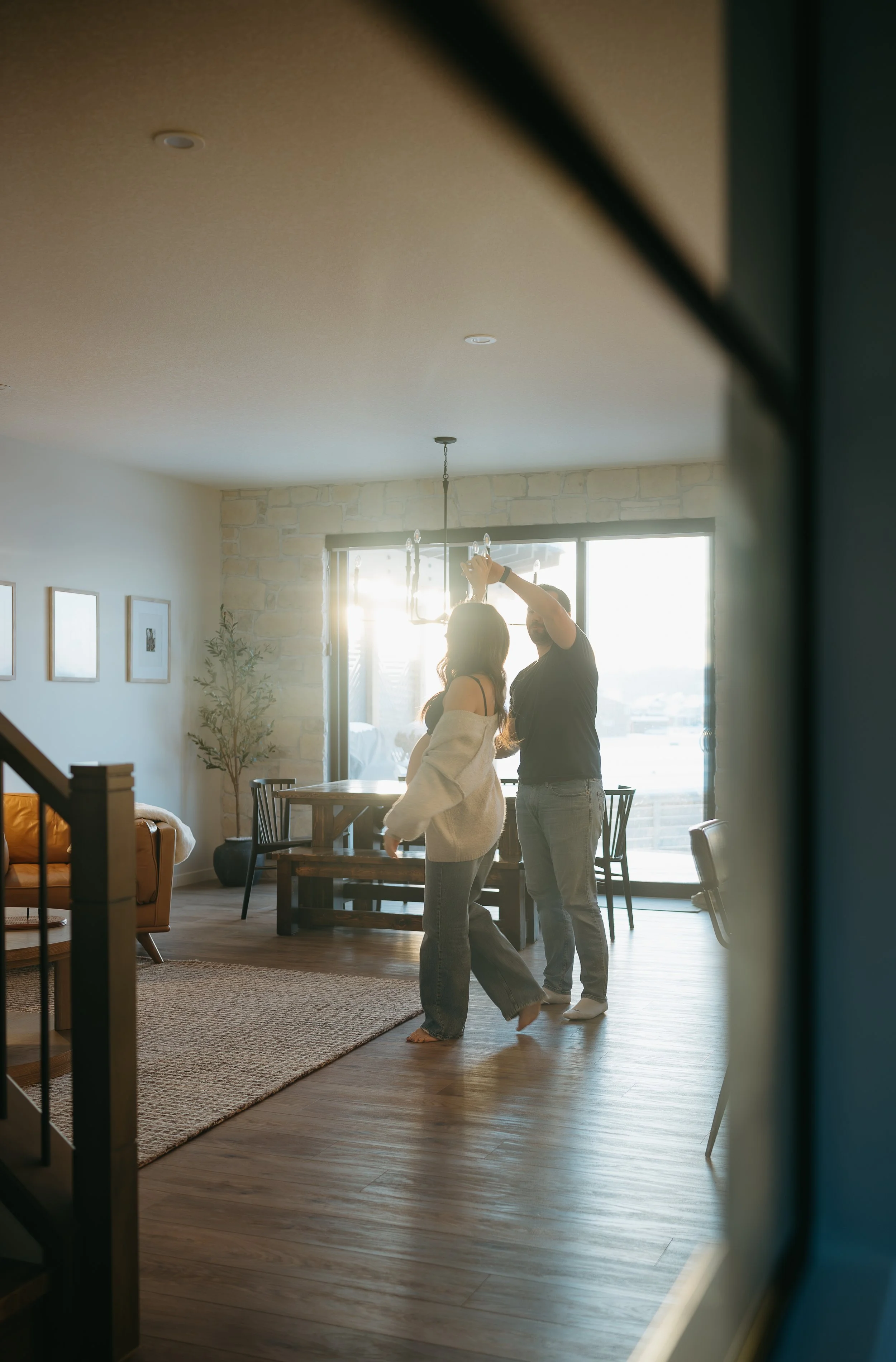 Calgary, Alberta Maternity Photographer.  Pregnant women and partner dancing in the house for maternity session