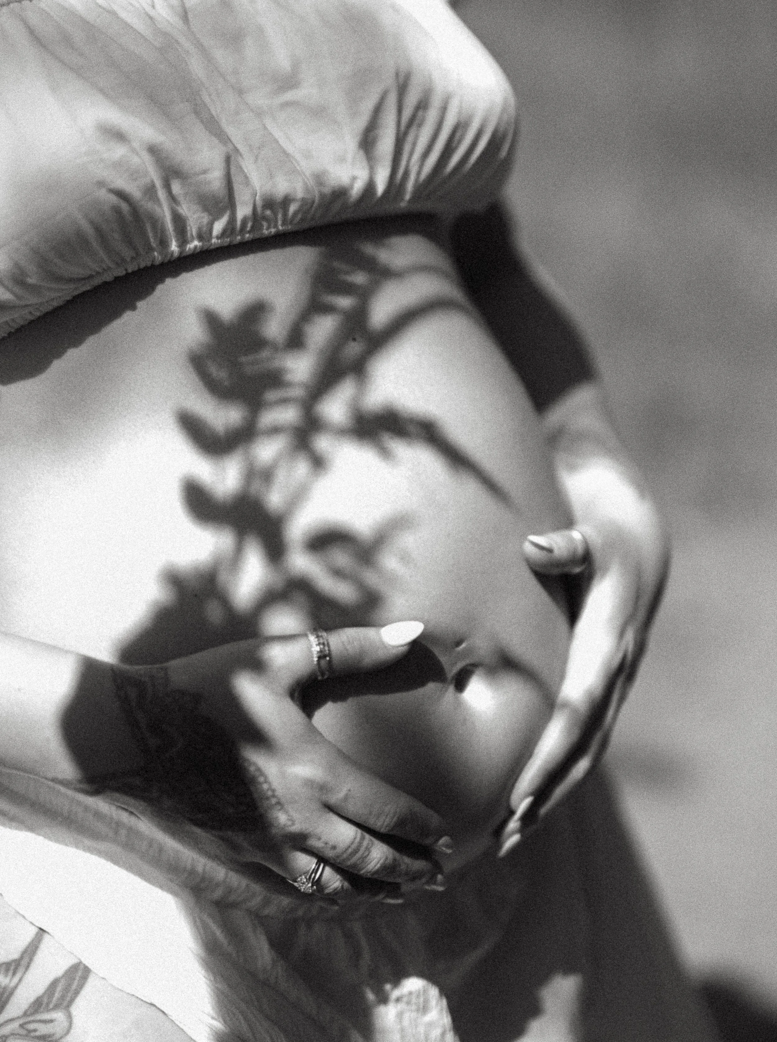 A close-up shot of a pregnant woman's belly as she holds it with her hands. Kananaskis Lifestyle/Family/Couple/Pregnancy/Maternity Session with KC Photography