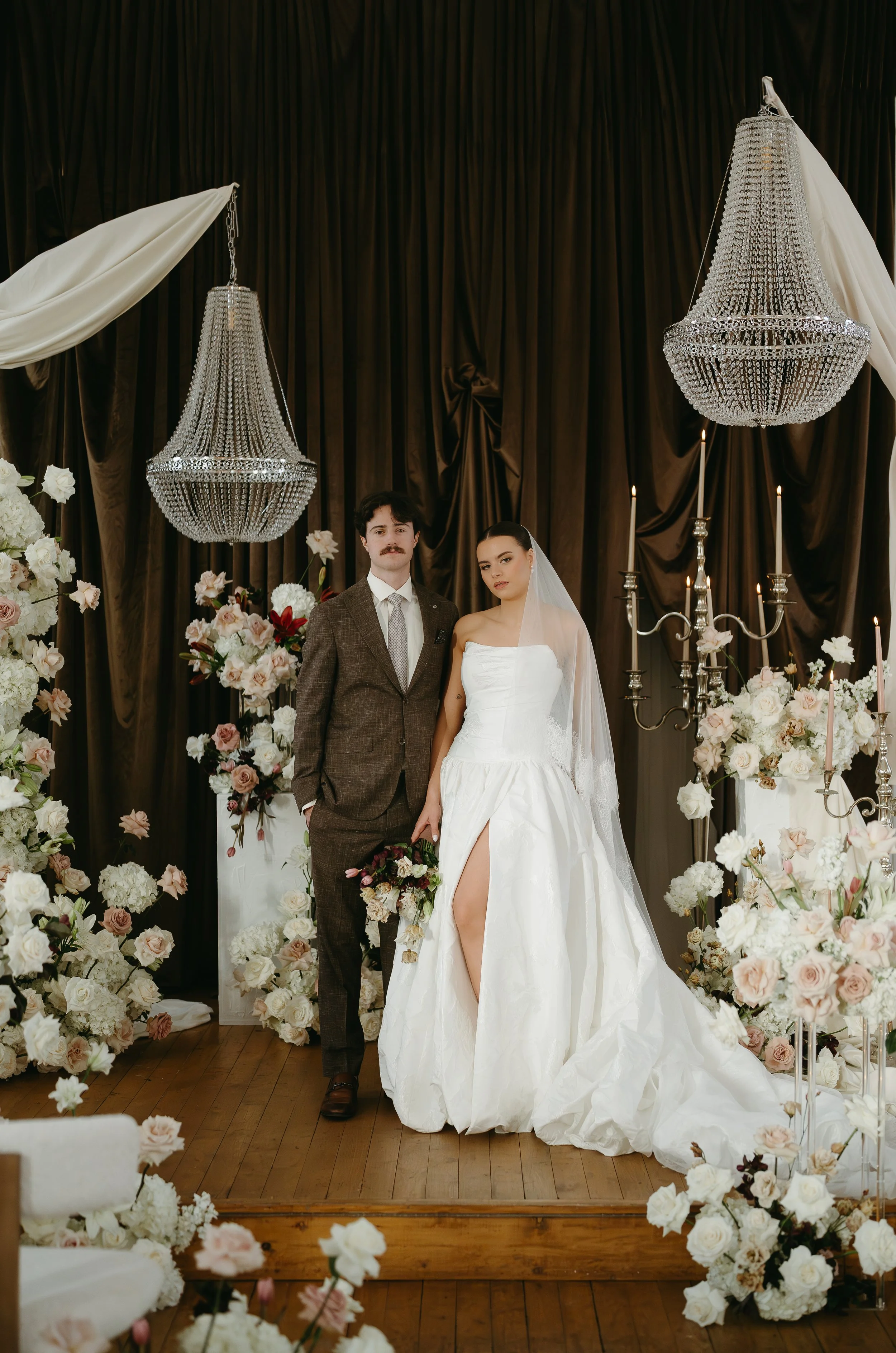 Little Chapel Co. Alberta Wedding Photographer KC photography.   Bride with veil over her head with unique natural lighting and tons of florals and chandeliers