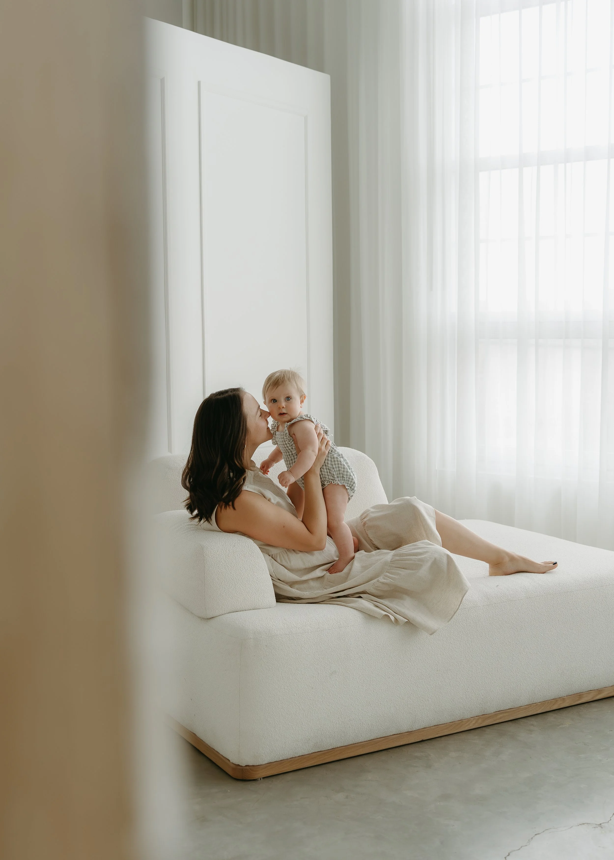 Calgary, Alberta. Lifestyle studio photography session of a mother and baby in natural light