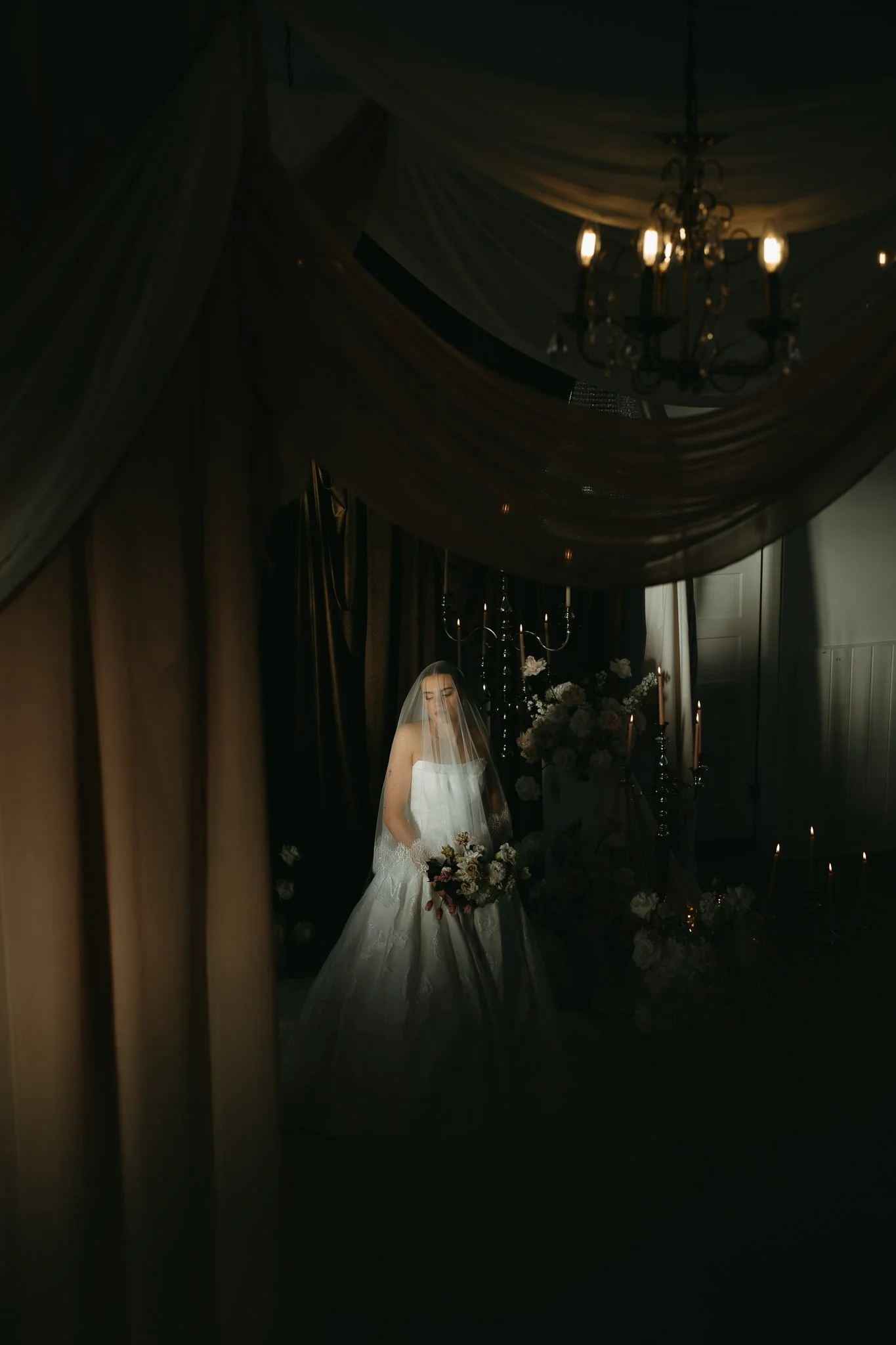 ALBERTA WEDDING PHOTOGRAPHER. MAGAZINE PHOTOS. BRIDE IN THE LIGHT BEAM WITH VEIL AND LOTS OF FLORALS. SMALL CHAPEL.