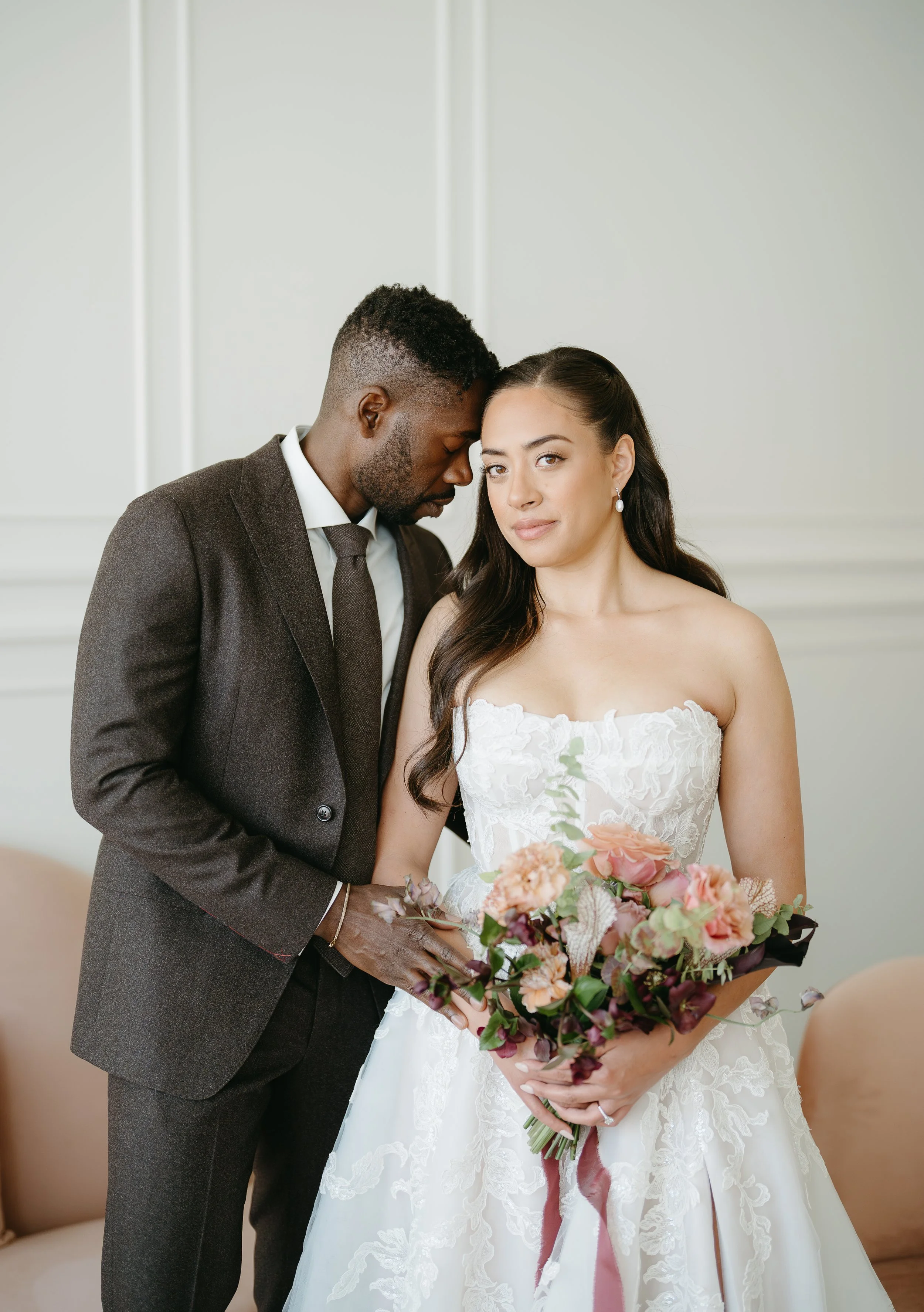 A groom holds his bride as she holds her bouquet and smiles at the camera. July 2025 Calgary Elopement/Wedding Editorial Session with KC Photography
