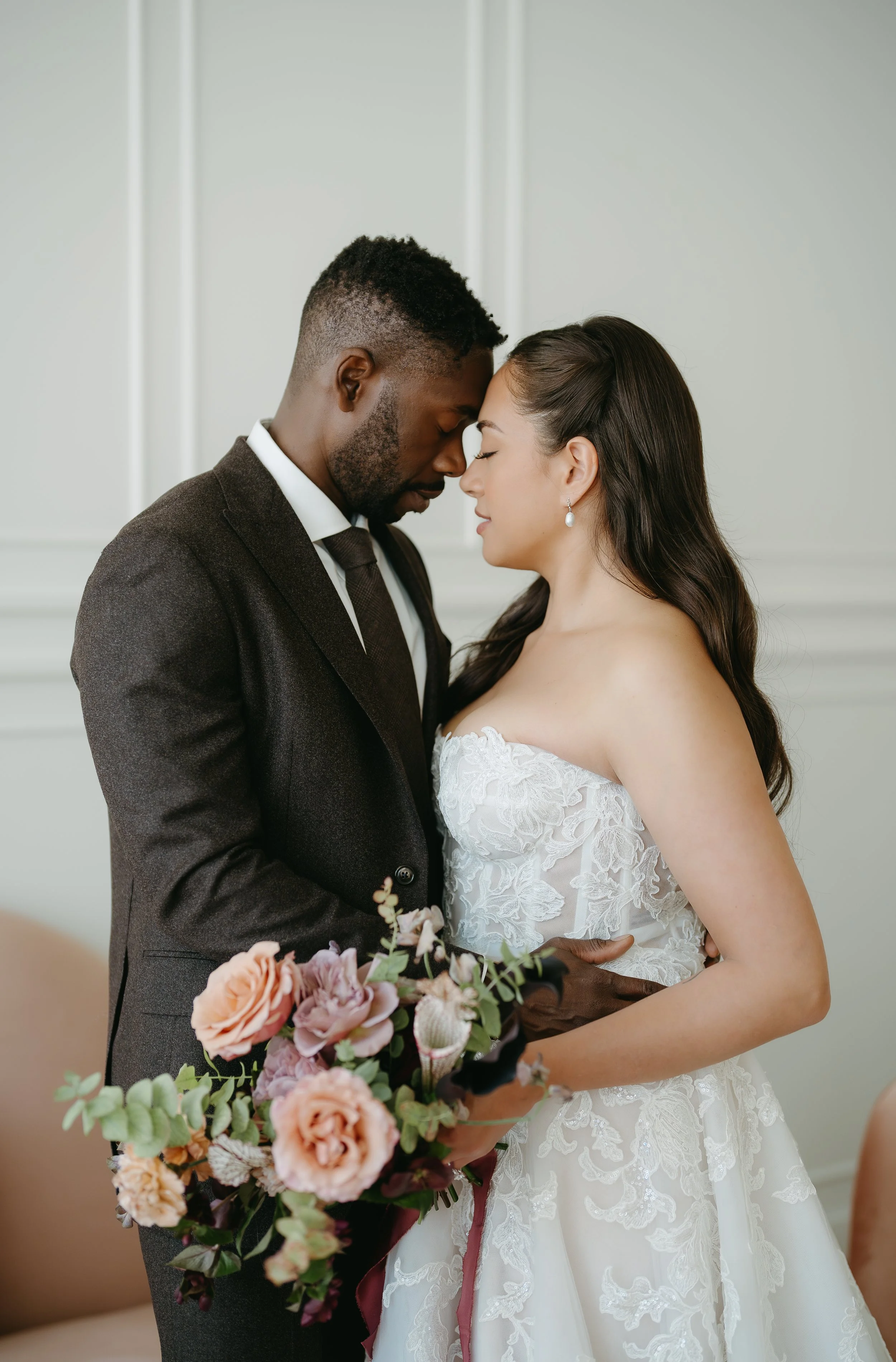 A groom holds his bride as they face one another touching foreheads with their eyes shut. July 2025 Calgary Elopement/Wedding Editorial Session with KC Photography