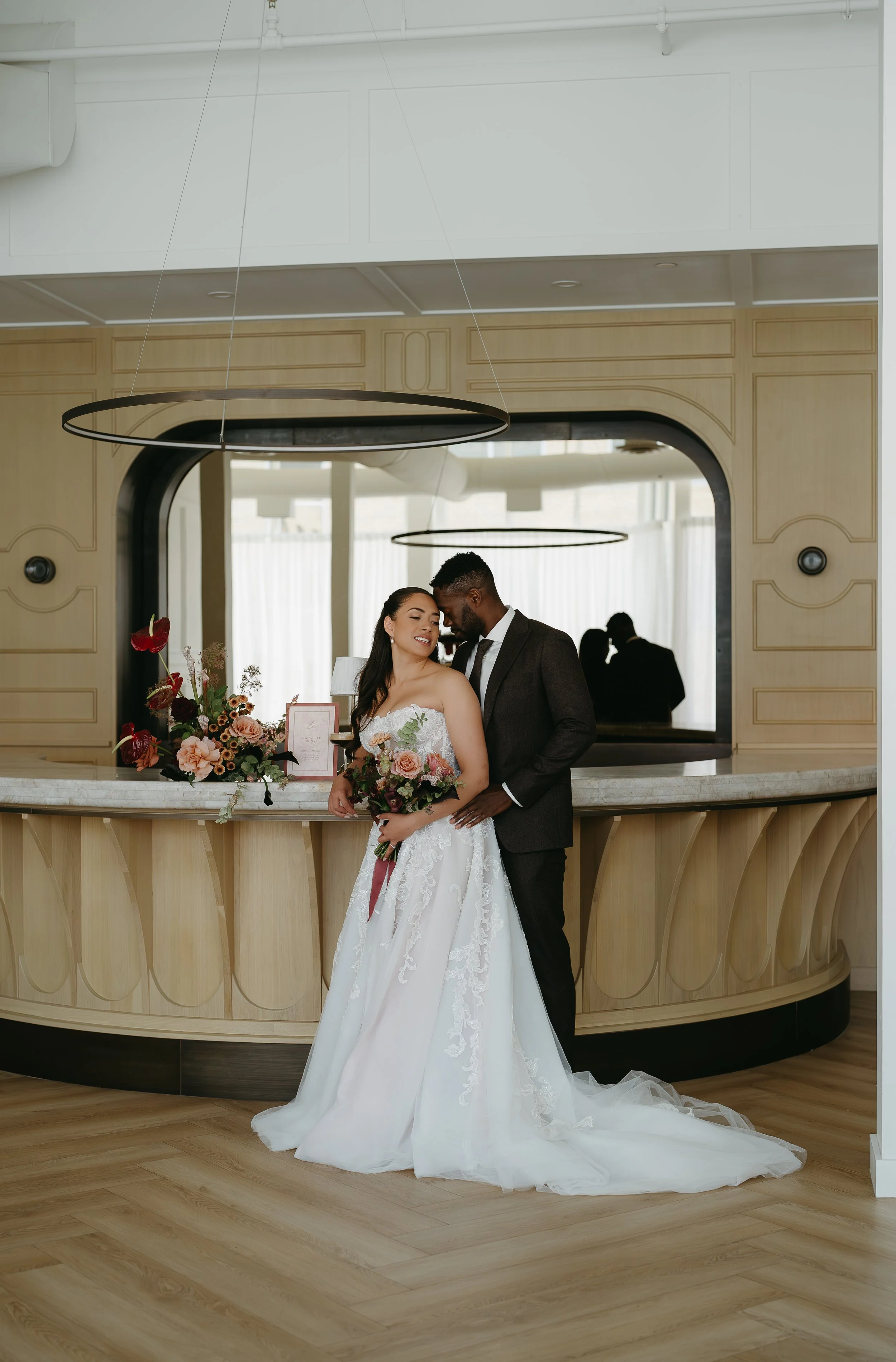 A groom holds his bride as she turns toward him holding a bouquet of flowers. July 2025 Calgary Elopement/Wedding Editorial Session with KC Photography