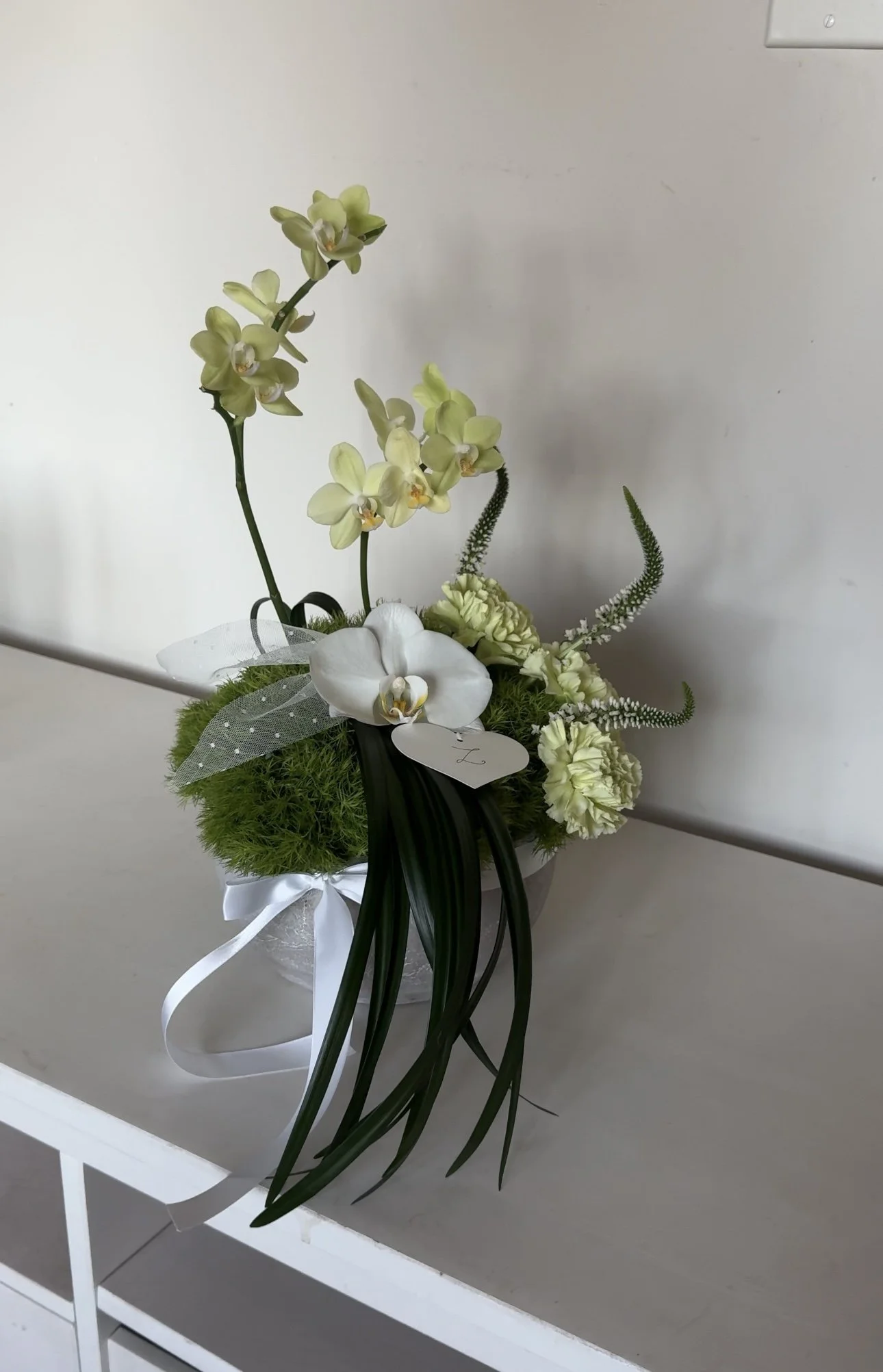 The three soft buds represent the whole family held within the same circle. The cascade of leaves, flowing like a quiet waterfall, honors the place that always has been apart of your beginning. 
Os três botões delicados representam toda a família man