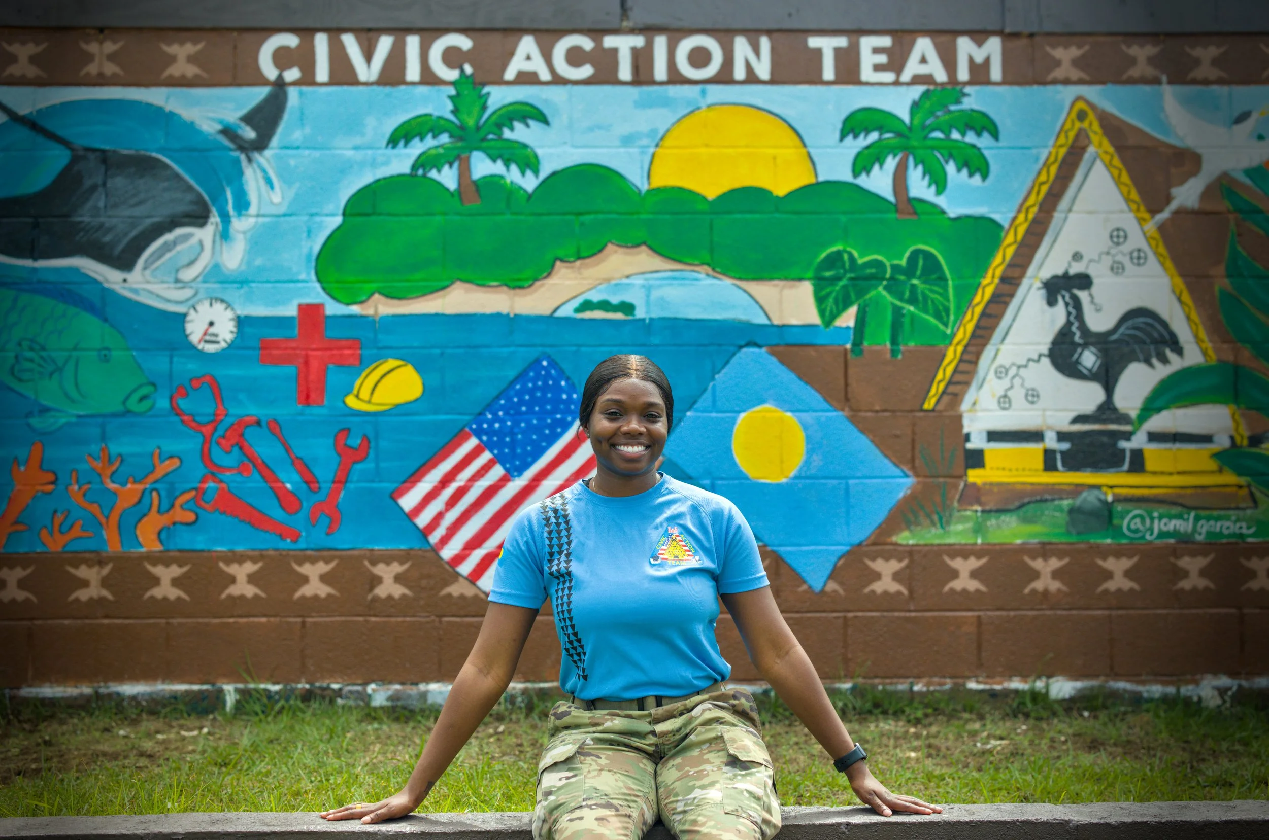 A soldier wearing a U.S. Army camouflage uniform with a name tag 'McDONALD' standing against a plain beige background.