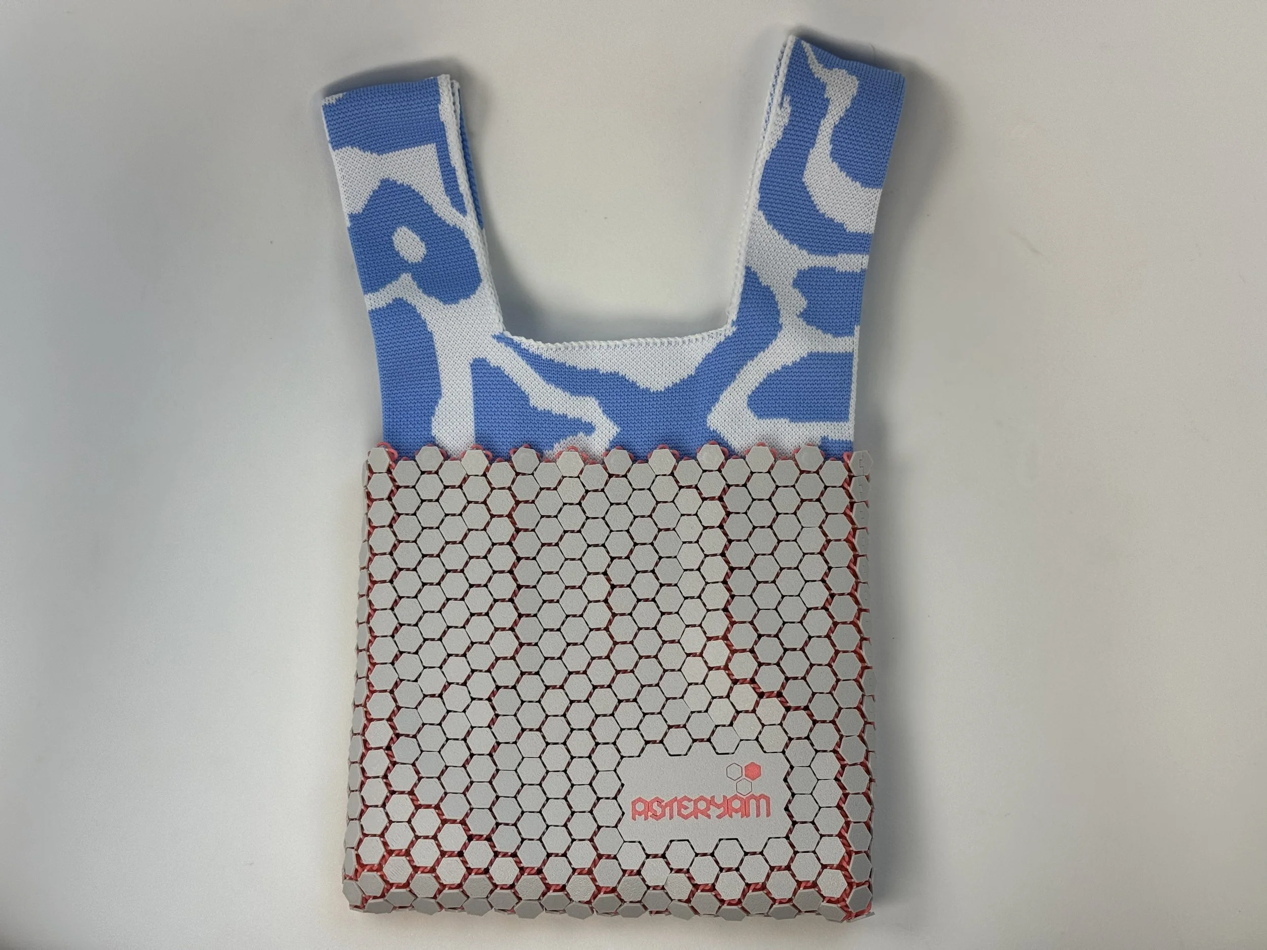 Front view of Hexa Sling without strap, highlighting the "Soft Futurism" knit handle and grey shell.