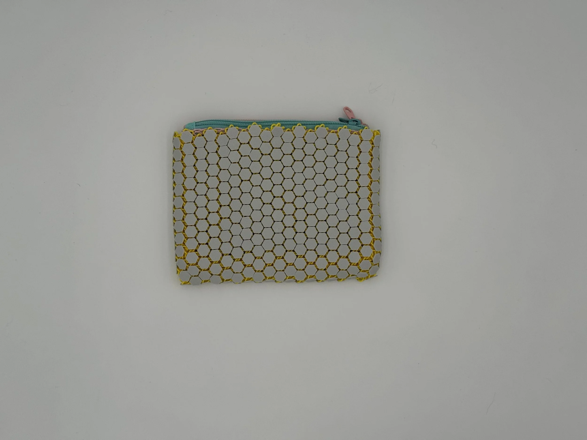 Back view of the HexaDuo pouch showcasing the continuous, flexible light grey hexagonal chainmail pattern without the logo, highlighting the geometric weave.