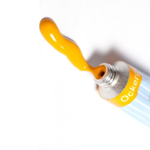 A yellow liquid being released from a metallic marker or highlighter pen.
