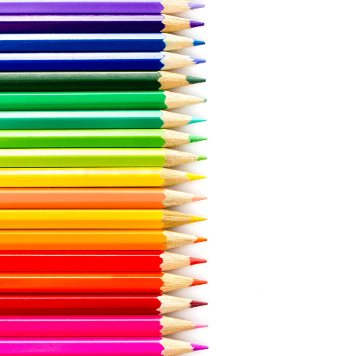 A row of colored pencils arranged in a rainbow pattern on a white background.