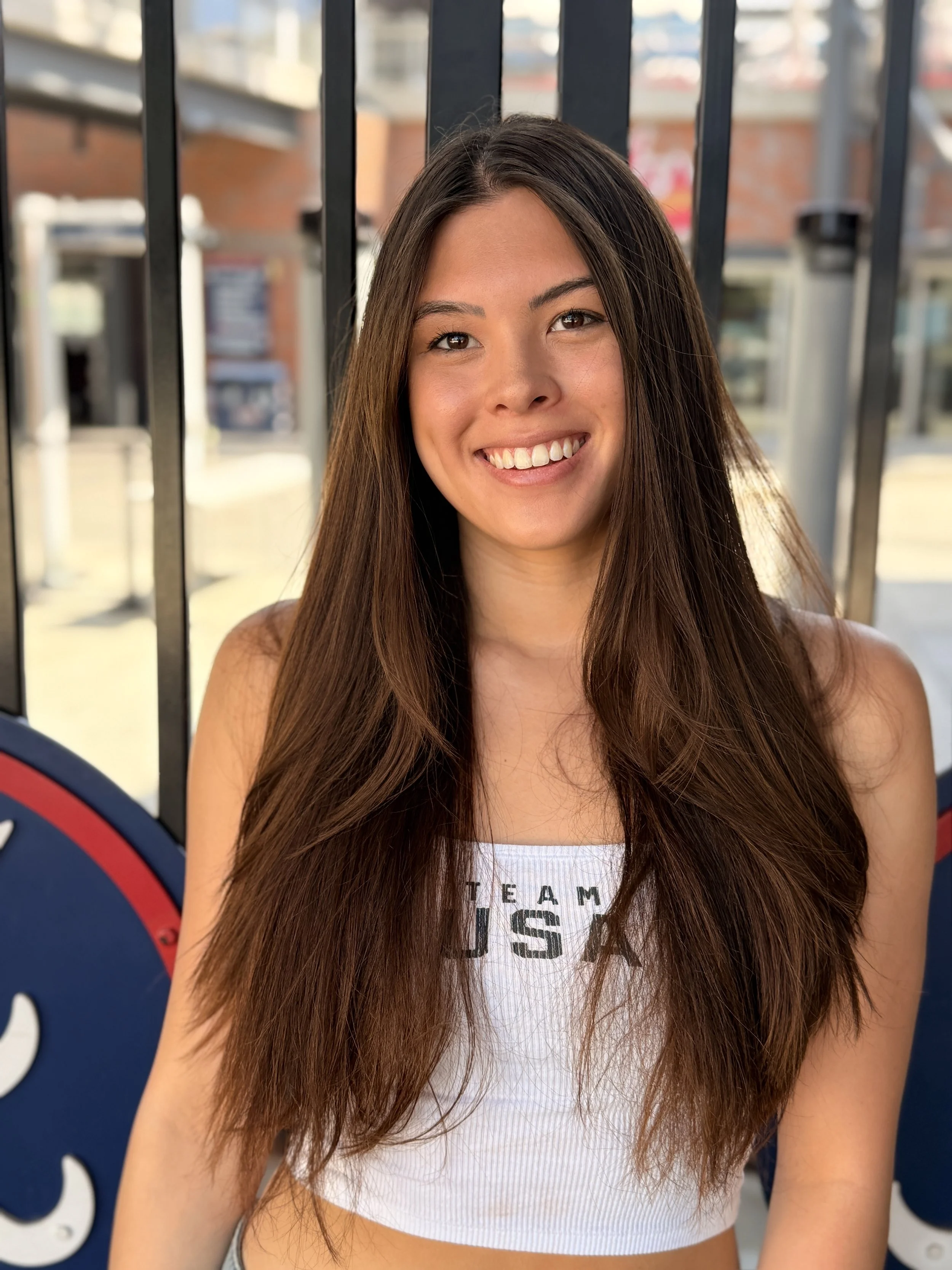 Gia Pergolini of the U.S. Women's Paralympic Swimming Team wearing a white Team USA tank top at the gates of Truist Park in Atlanta, Georgia.
