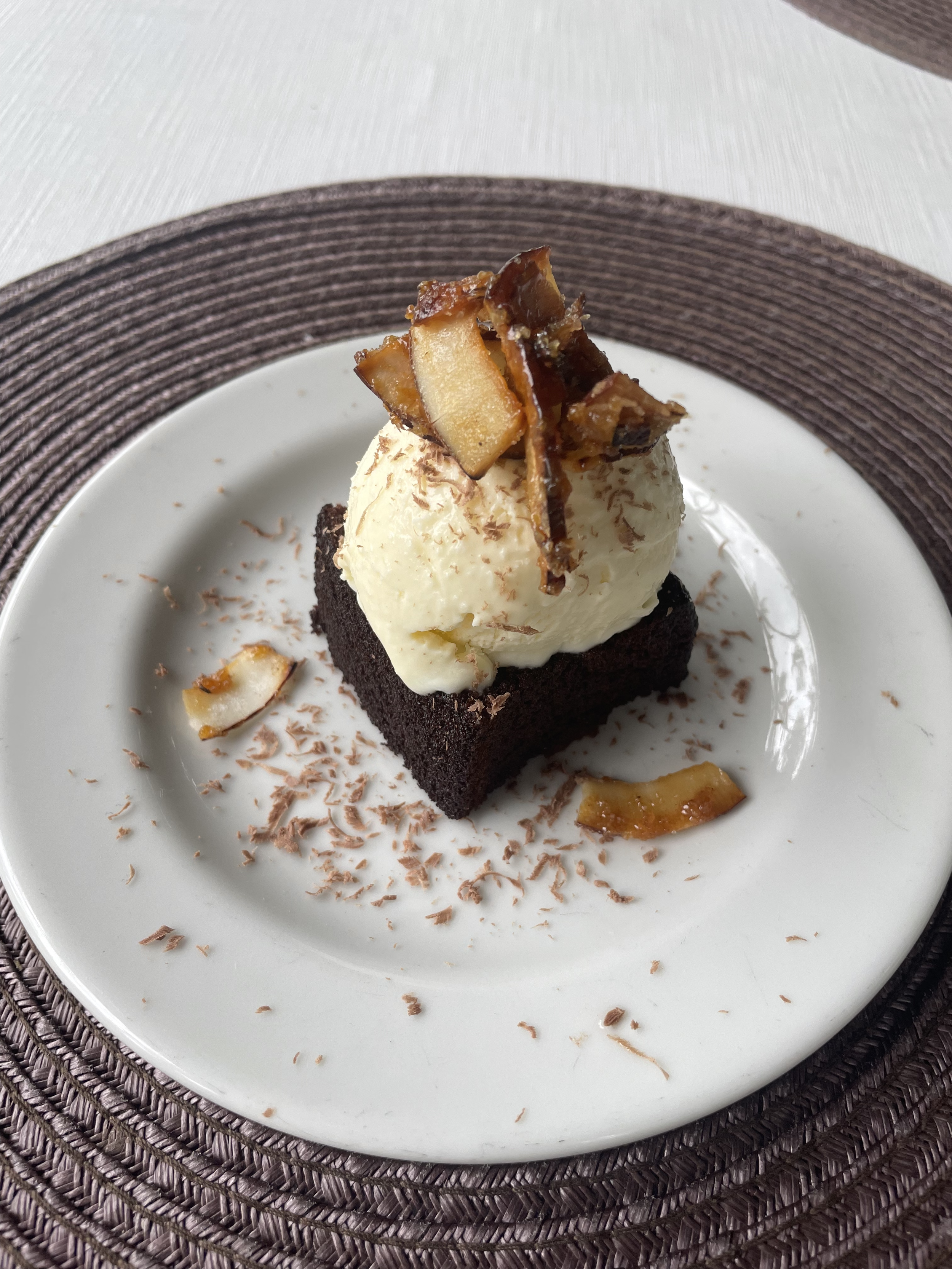 Postre de brownie de chocolate con helado homemade de vainilla y trozos de coco artesanal