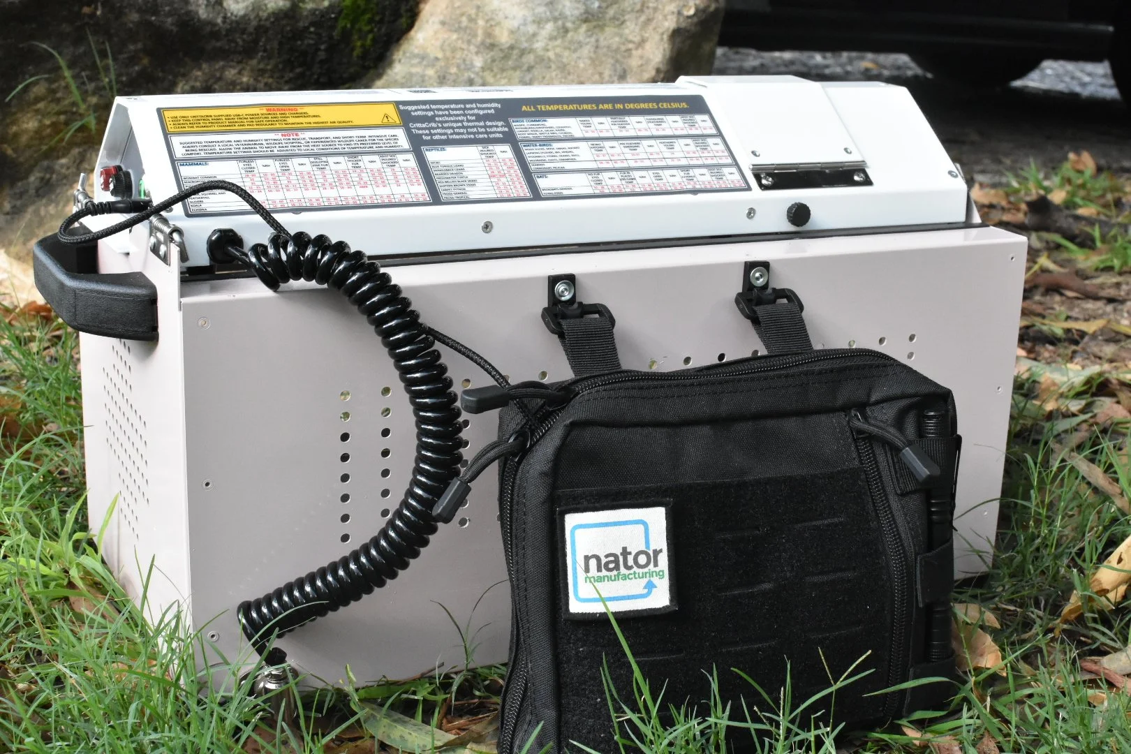 a pink and white PinkyCrib wildlife intensive car unit made from powder coated aluminium with a black bag attached with the words Nator Manufacturing written on the black bag
