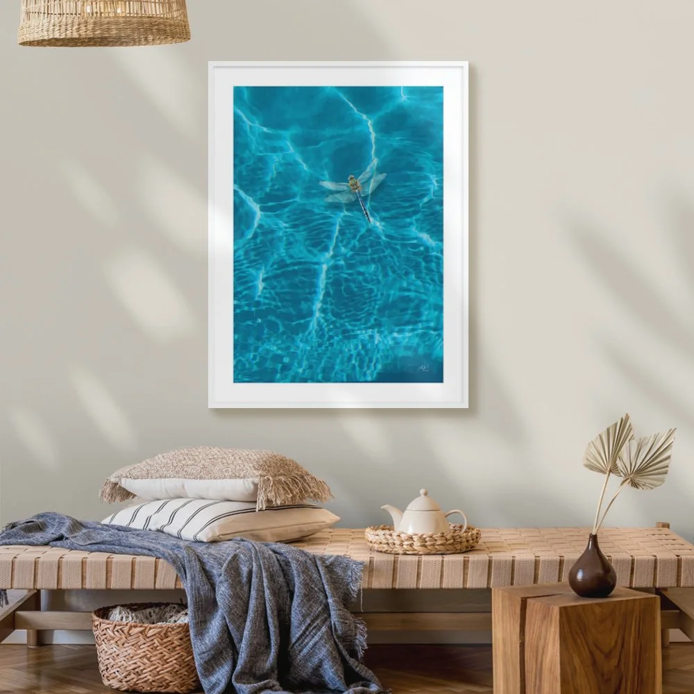A digital painting of a dragonfly hovering over clear blue water. Wall art print is called Dragonfly.