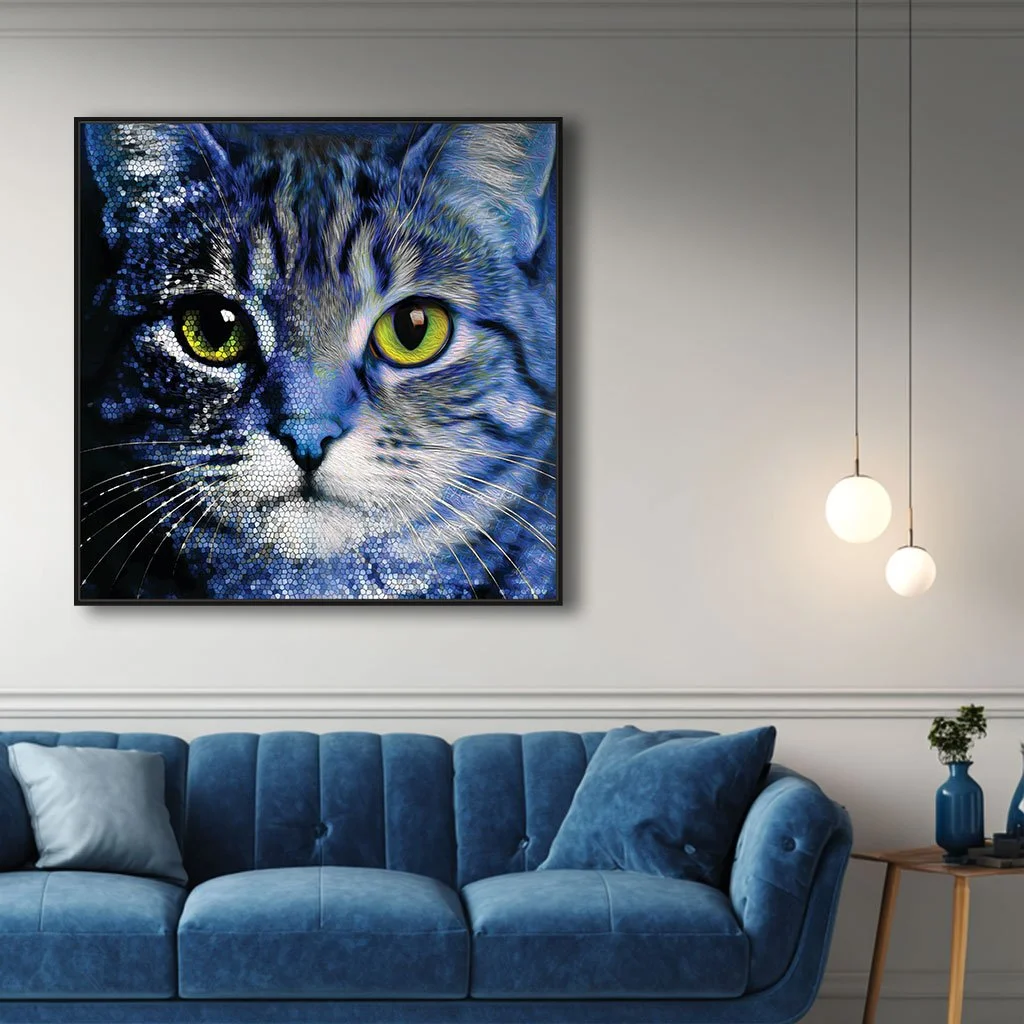 A framed mockup of an abstract cat art print displayed on a living room wall, showcasing vibrant blue and green tones and a detailed mosaic texture that adds a pop of color to the space.